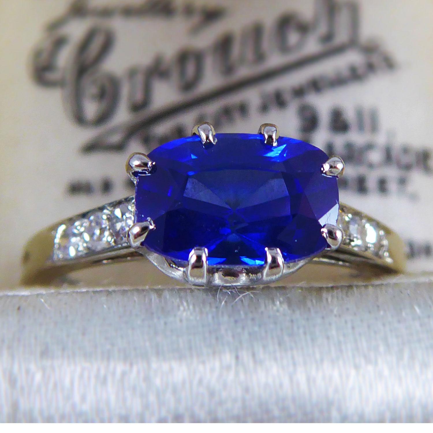 A delightful sapphire and diamond dress ring set with a principal oval cushion shaped, mixed cut sapphire which has been set across the finger in a white basket mount.  The sapphire measures approx. 7.38mm x 5.06mm x 4.28mm deep and weighs 1.41ct