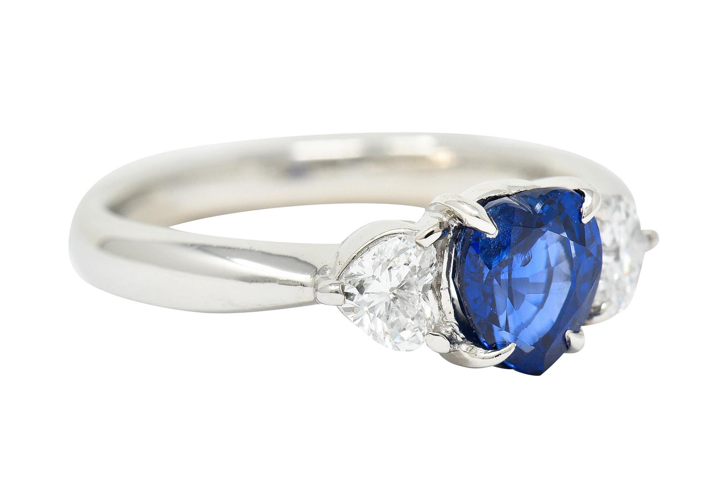 Three stone ring centers a heart cut sapphire weighing approximately 1.14 carats

Transparent with vibrant medium dark royal blue color

Flanked by two heart cut diamond weighing in total approximately 0.34 carat - H/I color with SI clarity

Stamped
