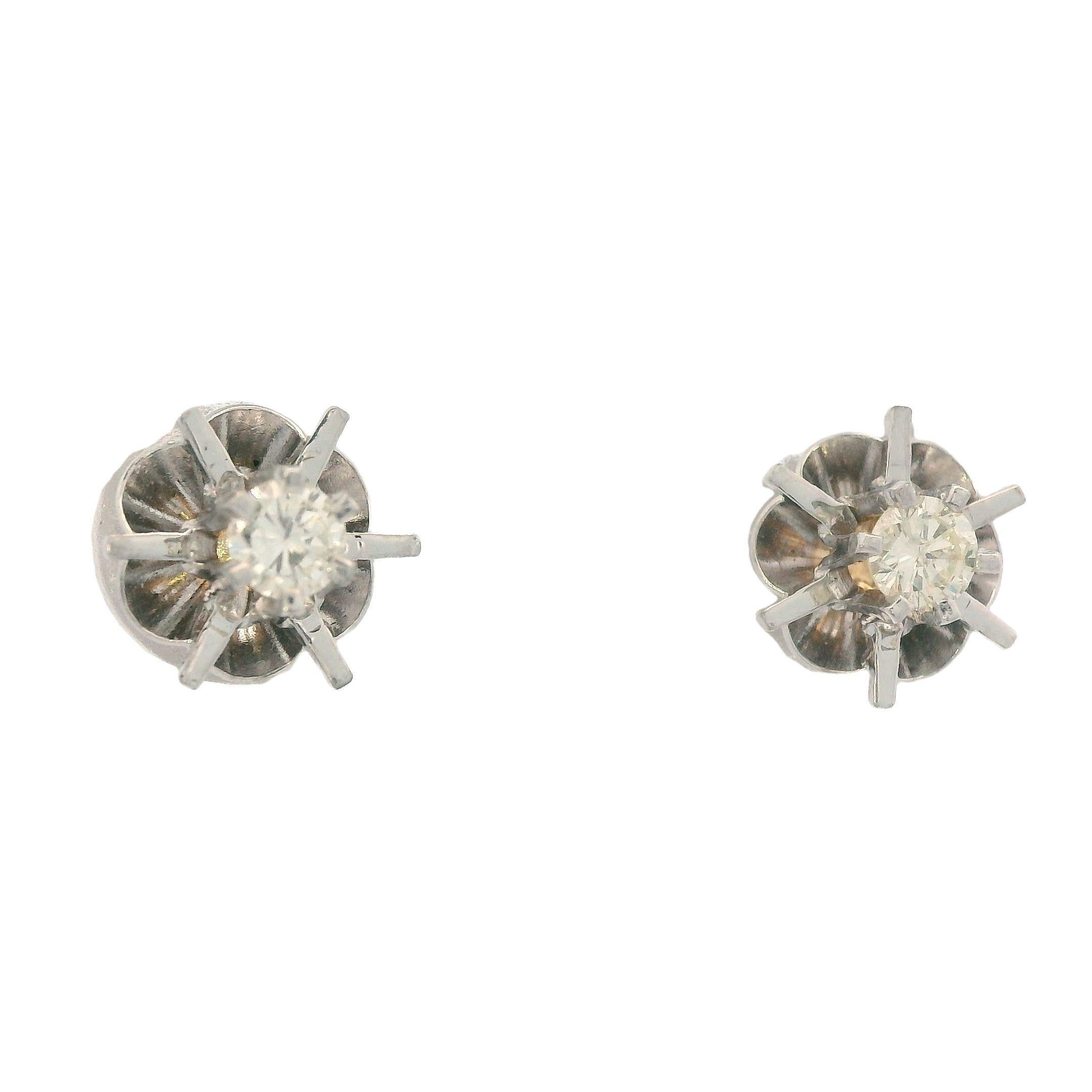 This is a pair of contemporary buttercup styled stud earrings, in 14k white gold, with diamond center stones. This style of earring gets its name from the resemblance to the shape of the buttercup flower. There earrings are traditional buttercup