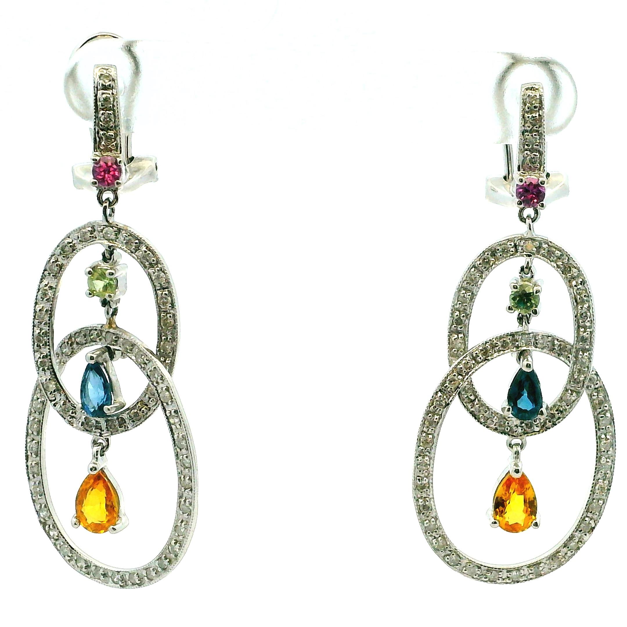 Estos contemporáneos pendientes en forma de gota están elaborados en oro blanco de 14 quilates y firmados DD, y muestran una elegante interacción de diamantes y vibrantes piedras preciosas. El diseño presenta elementos ovales entrelazados engastados