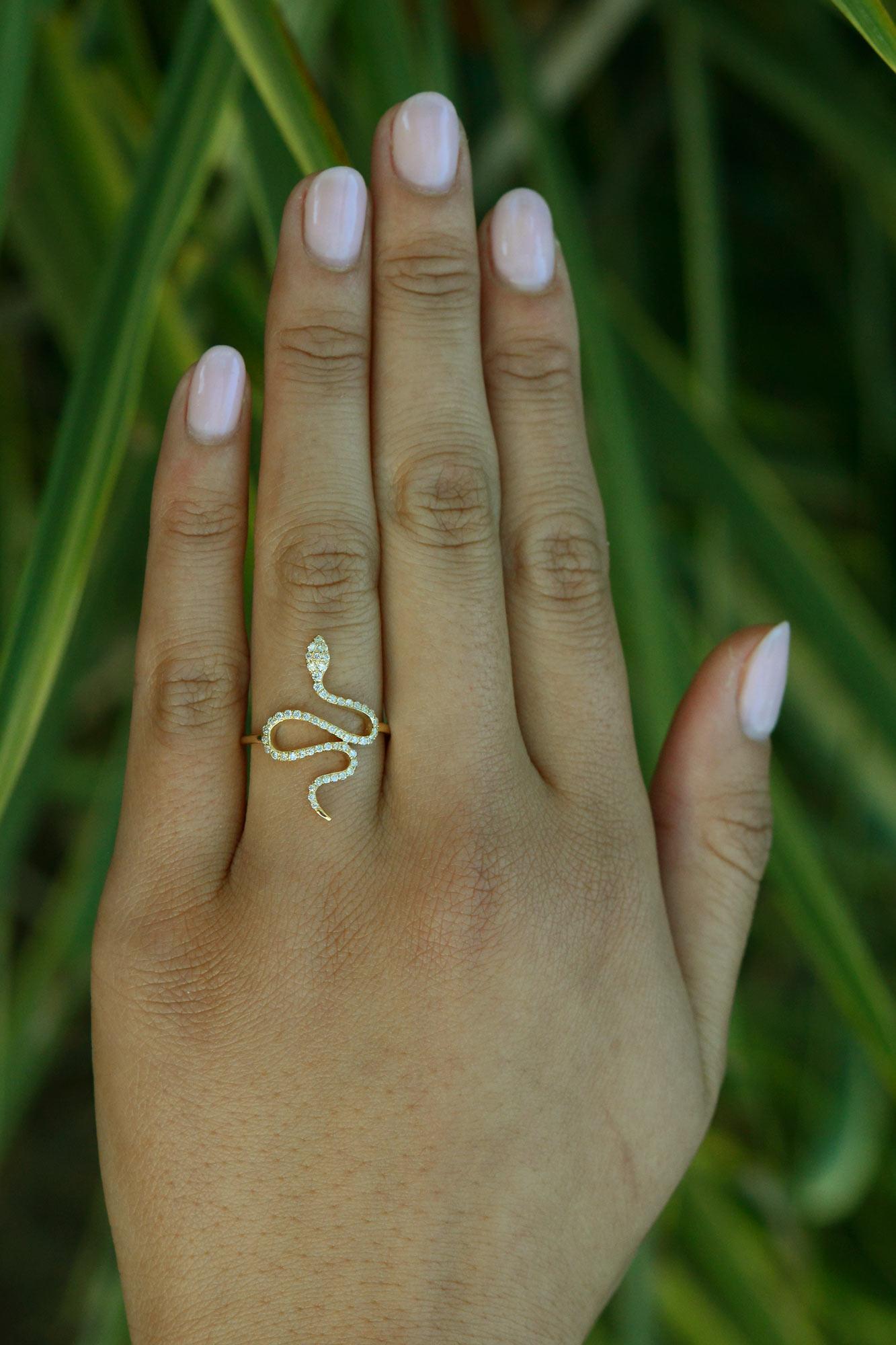 A contemporary and luxurious snake ring, paying homage to Egyptian style jewelry with a modern twist. The slinky serpent adorned with intricate pavé set diamonds total over a quarter carat in weight, set in enduring 14 karat yellow gold. The narrow