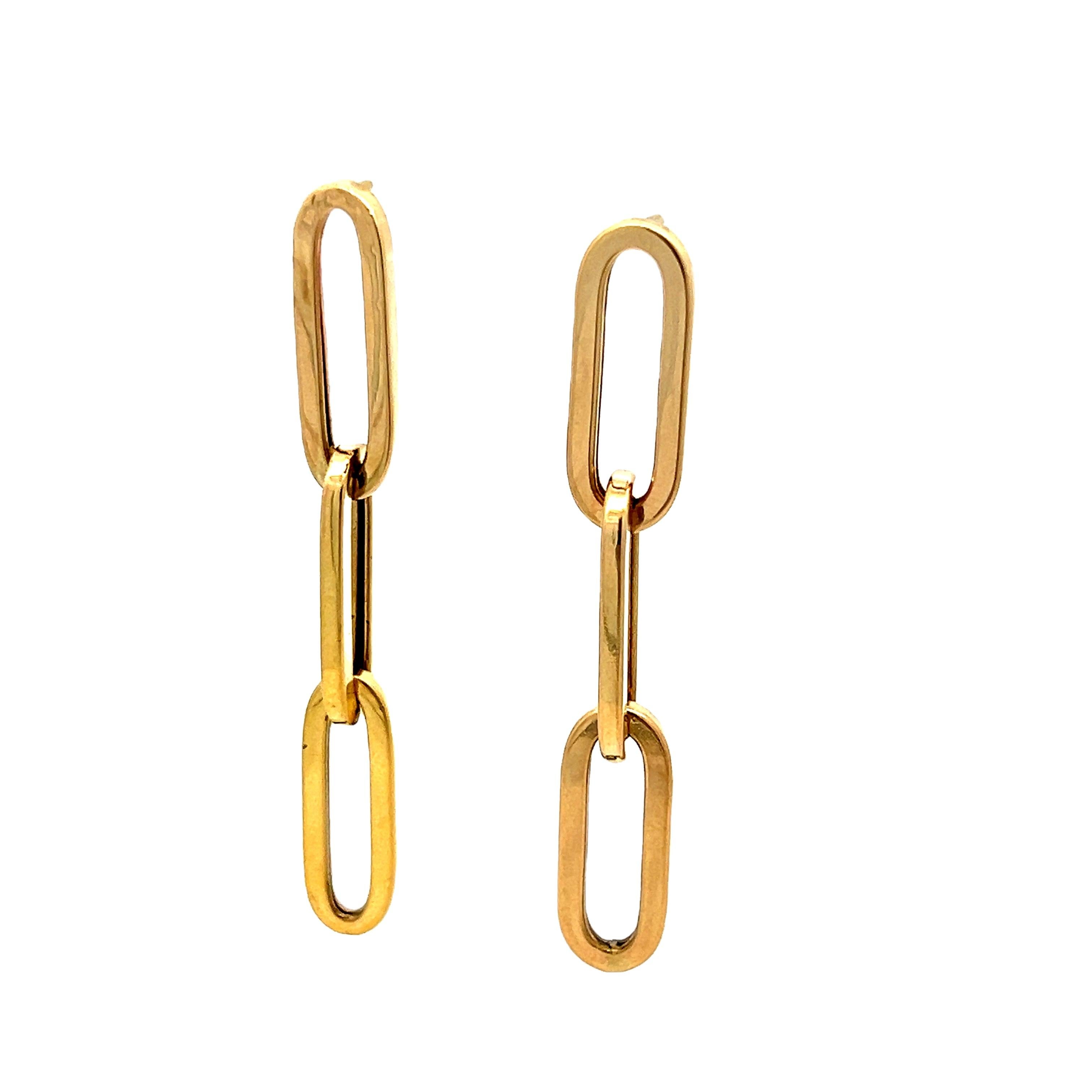 Minimalist and modern, these elongated drop earrings are crafted in 14 karat yellow gold and feature a sleek paperclip link design with three articulated oval links per side. The polished finish adds a luminous, mirror-like effect, enhancing the