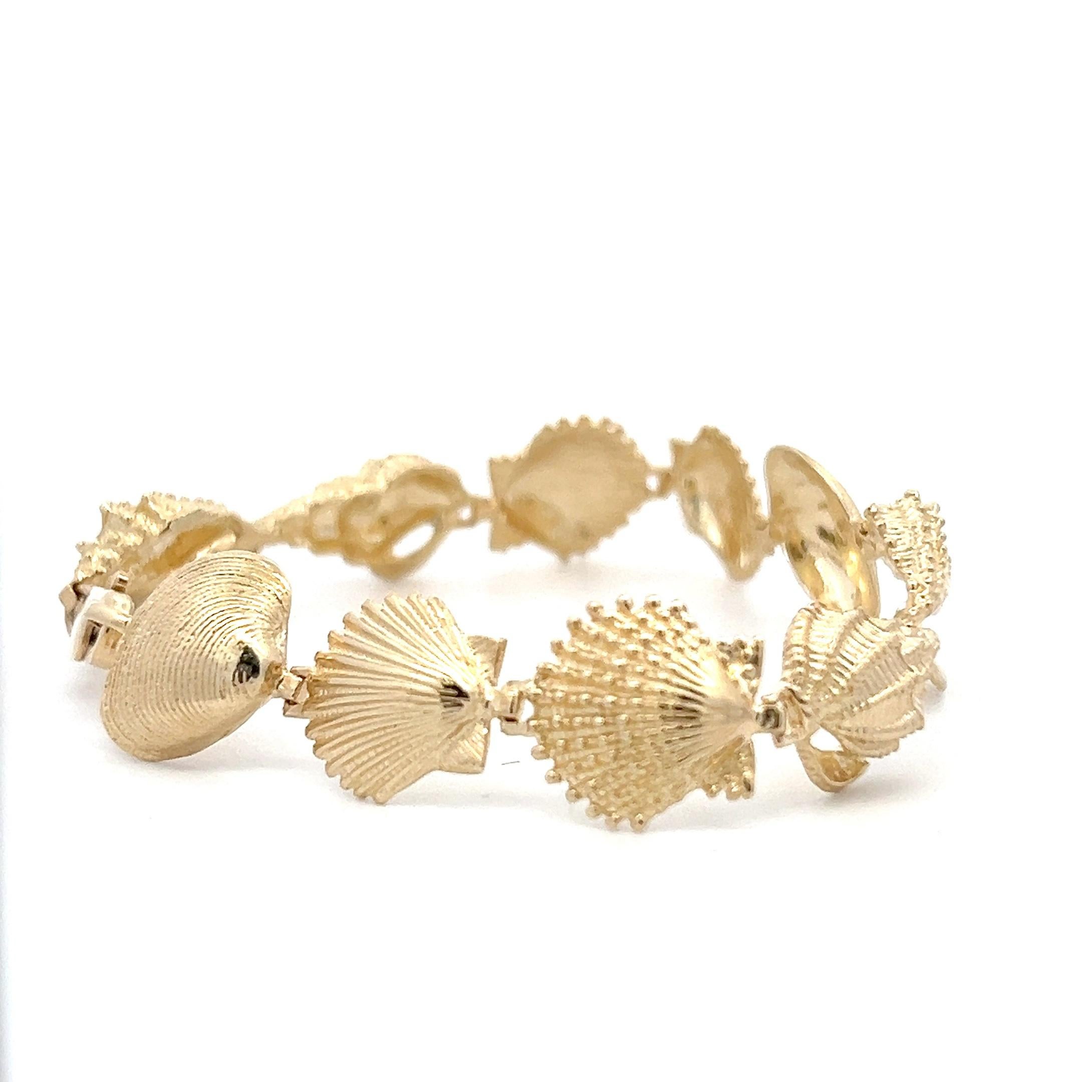 One contemporary 14 karat yellow gold seashell link bracelet featuring five distinct seashell designs, each beautifully crafted to capture the charm of the ocean. This bracelet is 7.5 inches in length and 0.59 inches in width, weighs 17.71 grams and