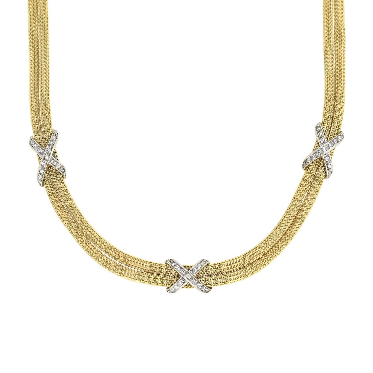 A stunning contemporary diamond necklace! This fabulous piece is comprised of two vibrant 14kt yellow gold mesh chains that come together to form a classic yet bold appeal. Three 14kt white gold x-shaped motifs cinch the two chains in a symmetrical