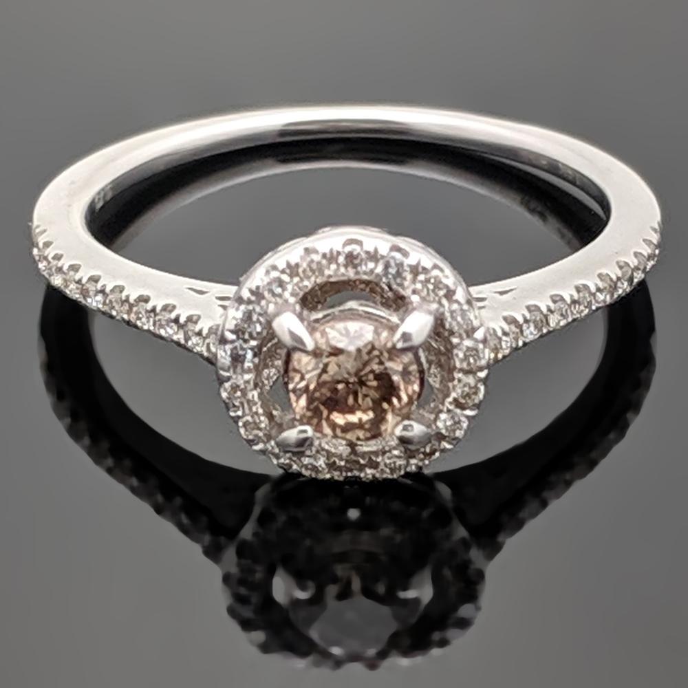 This ring features a center diamond that is round brilliant cut with an estimated weight of 0.24ct with a halo of small diamonds as well as diamonds on the shoulders at an estimated 0.13 cttw. Estimated weight of gold is 1.5 gr. 

We will size it
