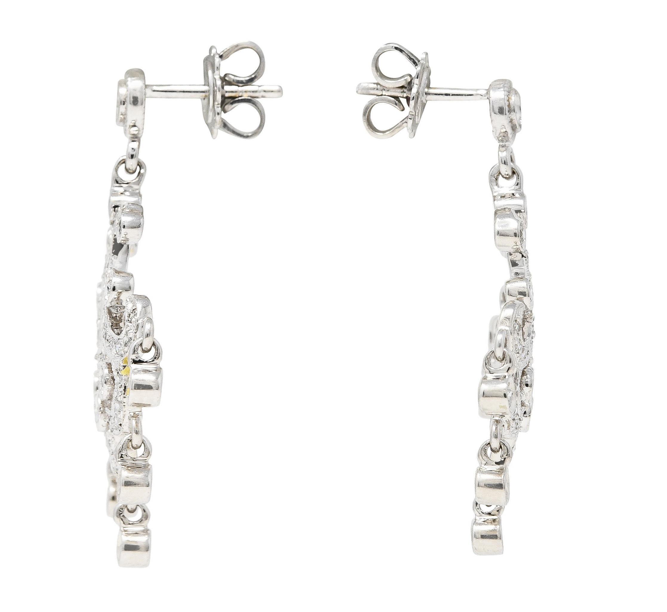Earrings are designed with a circular surmount. Suspending an ornate chandelier drop with articulated droplets. Set throughout by round brilliant cut diamonds. Weighing in total approximately 1.50 carats - G/H color with SI clarity. Completed by