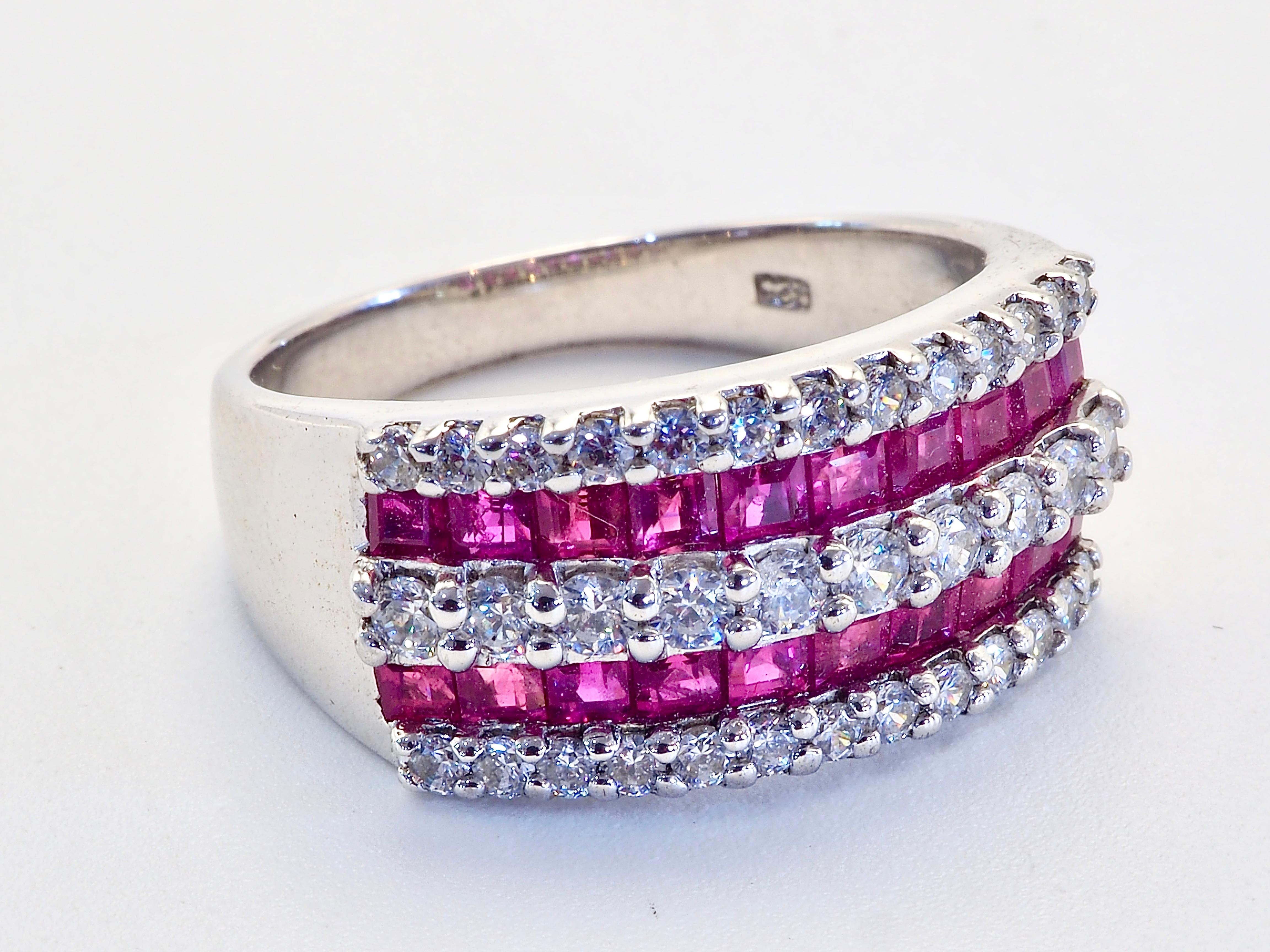 This ring is a beautiful band ring in solid sterling silver. The ring is decorated by multiple natural squared pinkish red ruby set beautifully on the face of the ring into rows. The white stone are quartz. The ruby gemstone is one of the most