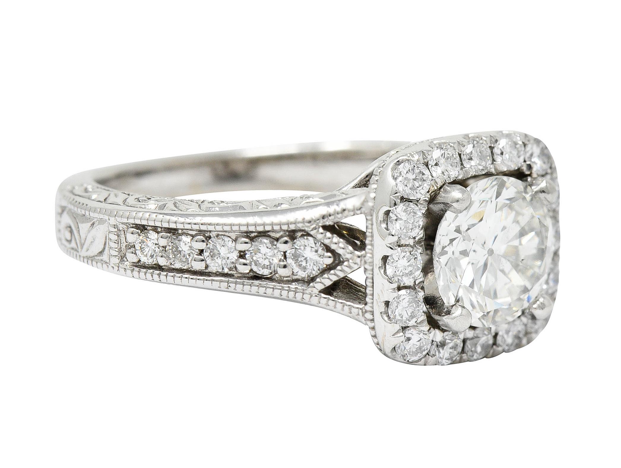 Designed as an ornate mounting with a scrolled volute gallery and pointed shoulders

Centering a transitional cut diamond weighing 1.02 carats - J color with SI1

With a diamond halo and diamond accented shoulders

Weighing in total approximately