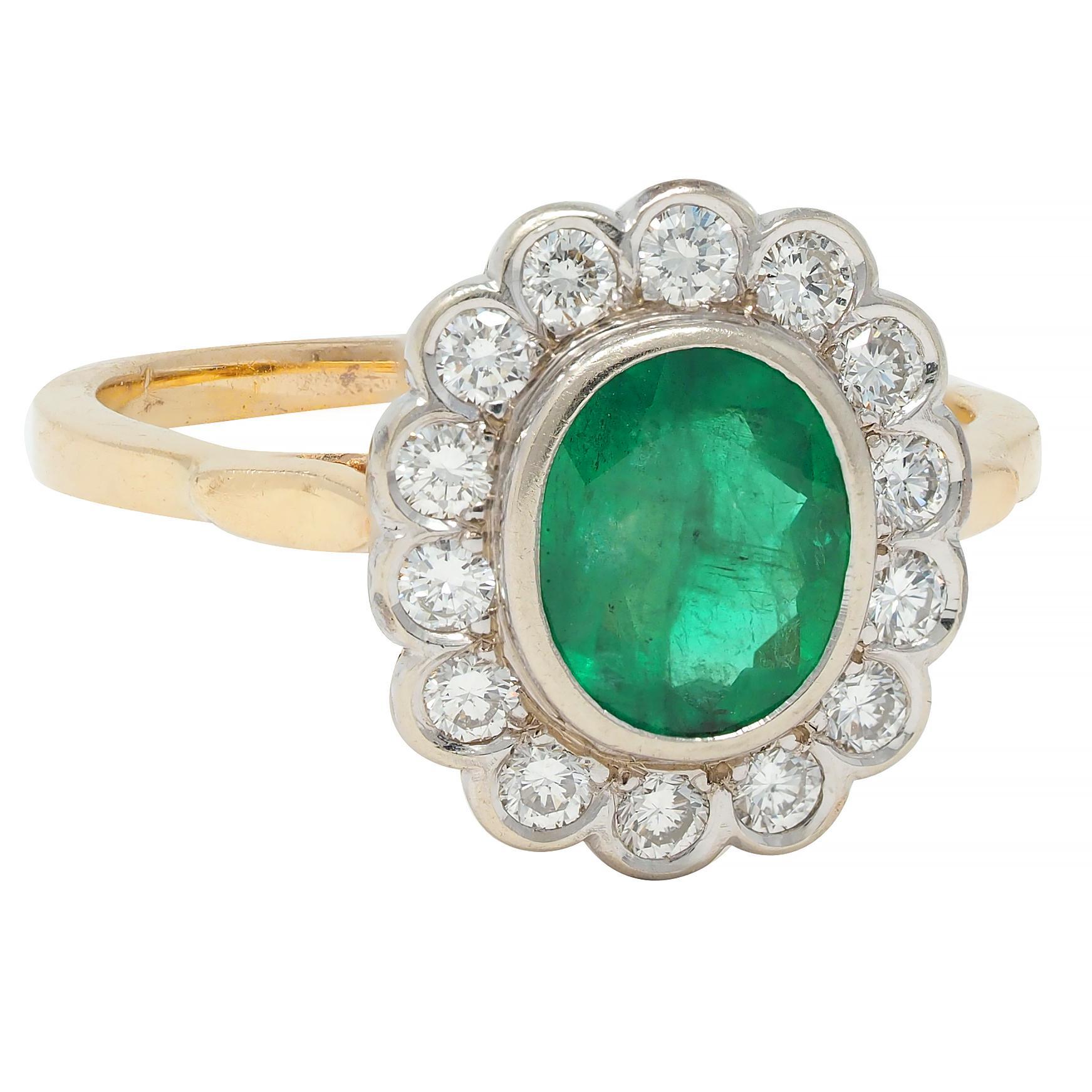 Centering an oval cut emerald weighing 1.18 carat total - transparent vibrant green in color
Natural Russian in origin and displaying no indications of clarity enhancement
Bezel set with a recessed halo surround of round brilliant cut