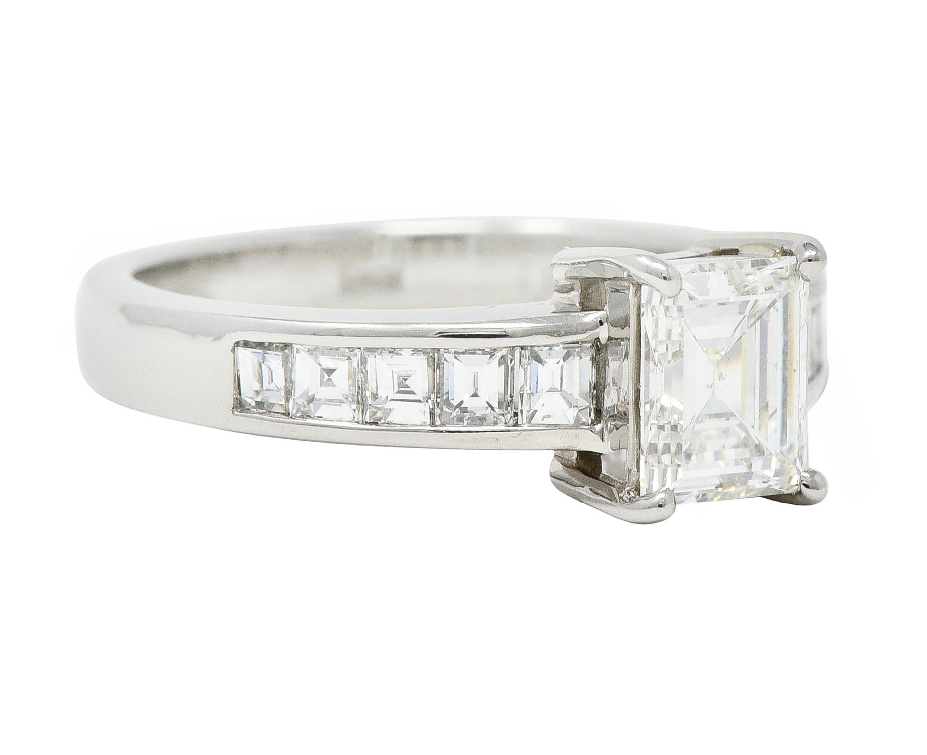 Centering a step cut diamond weighing 1.09 carats - F color with SI1 clarity
Prong set in basket and flanked by additional step cut diamonds
Channel set and weighing 0.70 carat total - G/H color with SI2 clarity
With high polish finish
Inscribed