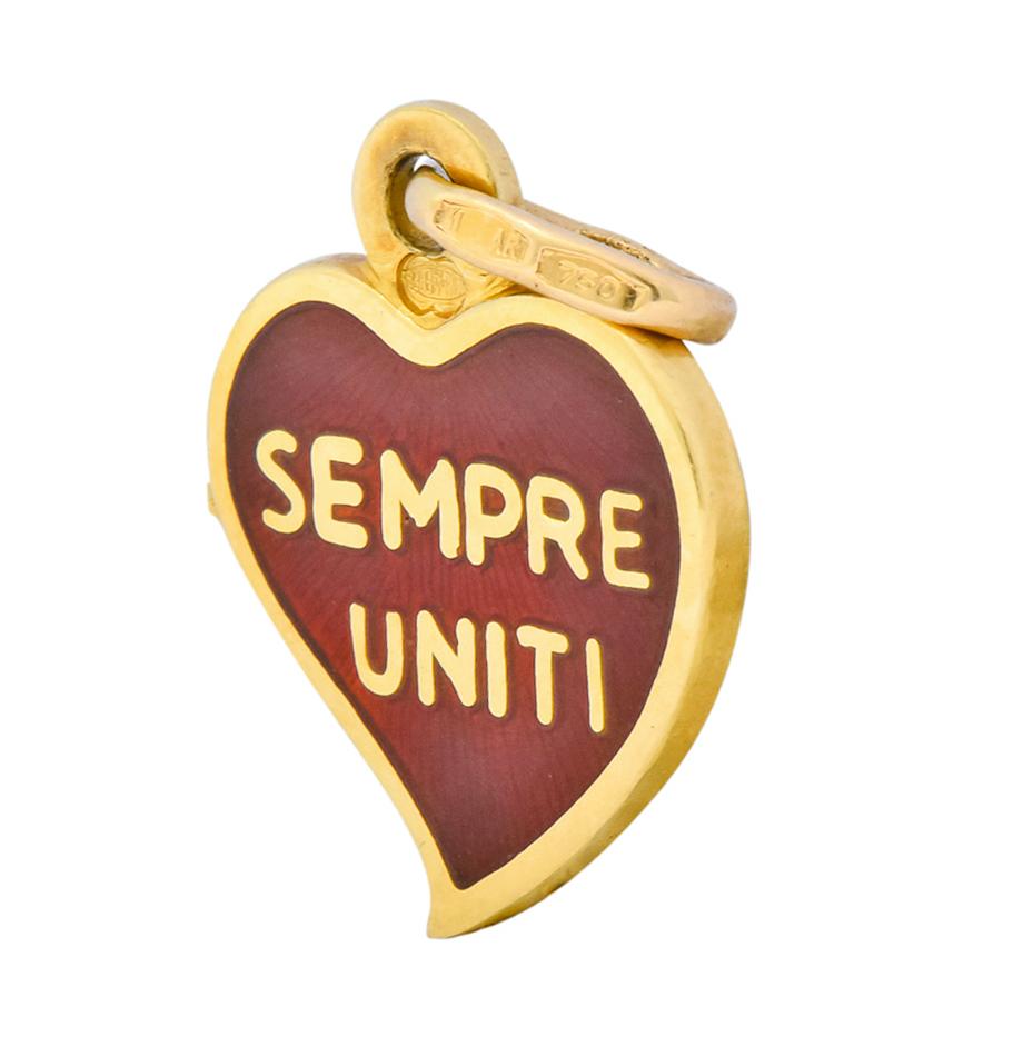A stylized heart charm in 18 karat gold with red enamel  “Sempre Uniti” on one side and “Divisi Ma” on verso

Translated from Italian as:  “Always United” “But Divided”

Marked 750 for 18 karat gold with Italian assay marks

Circa 1980 

Measures: