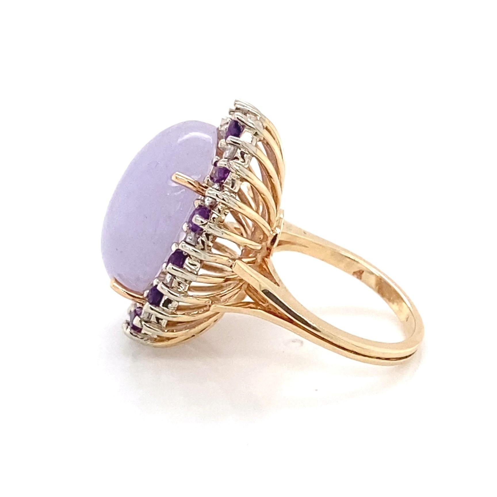 This big, bold, and beautiful 18.80 carat natural lavender jade cabochon is saturated with a soft, bright purplish color.  Prong set in 14 karat yellow gold, the lavender jadeite is surrounded by thirteen alternating 2.5mm round faceted rich purple