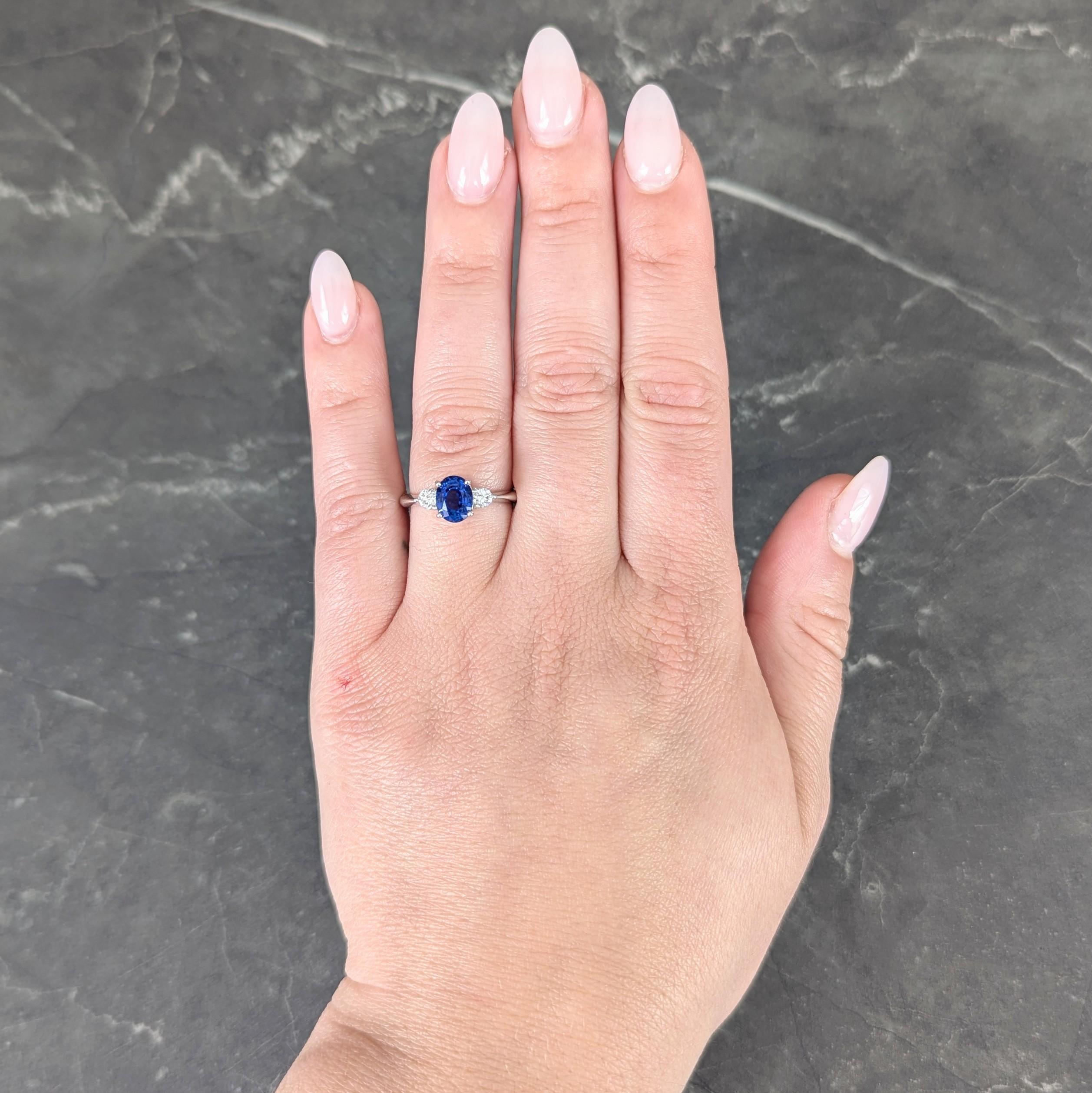 Centering an oval cut sapphire weighing 1.65 carats - transparent medium blue in color
Prong set in basket and flanked by prong set round brilliant cut diamonds
Weighing 0.24 carat total - H color with VS2 clarity
Flanked by tapered