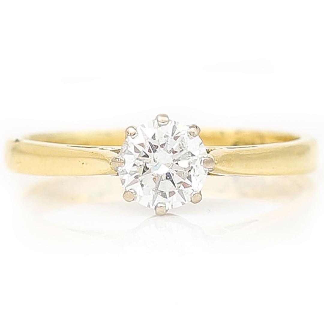 A beautiful contemporary 18ct yellow gold single stone brilliant cut diamond ring dating from the late 20th century. A timeless coronet set brilliant cut diamond of approx 0.60ct and of great colour J and clarity VS2. It would make for a beautiful