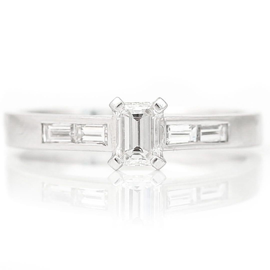 A beautiful stylish 18ct gold baguette cut diamond single stone diamond ring, with similarly cut diamond shoulders. The principal diamond weighs approx 0.40ct, H-I colour and VS clarity and the total diamond weight is 0.57ct. This contemporary,