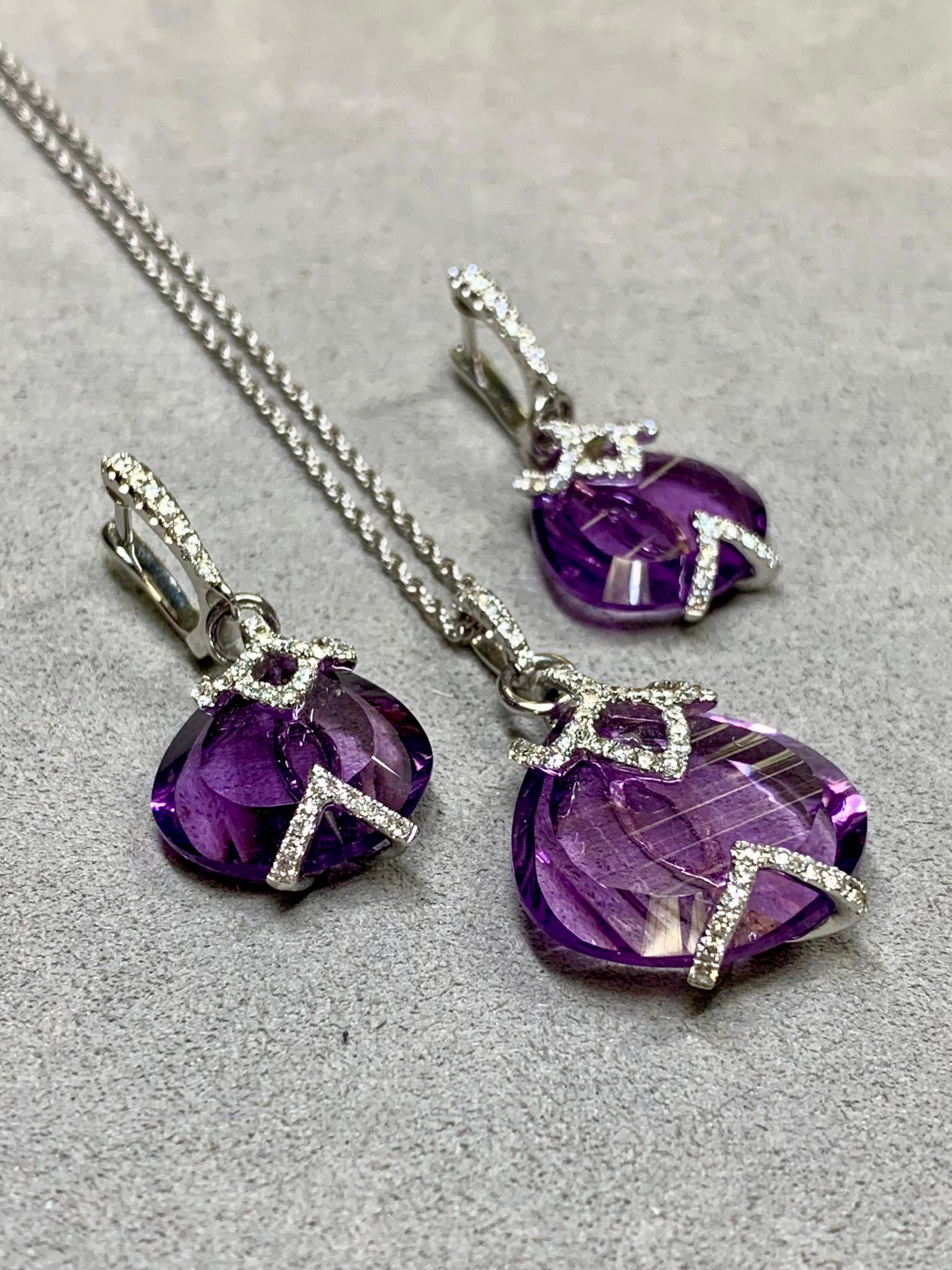 
A beautifully made necklace and earrings set comprised of fantasy cut, natural amethyst framed in 18k white gold and set with approximately 1.05ctw in H-I color Vs2-Si1 clarity round diamonds. The pendant comes on a matching 14k white gold chain