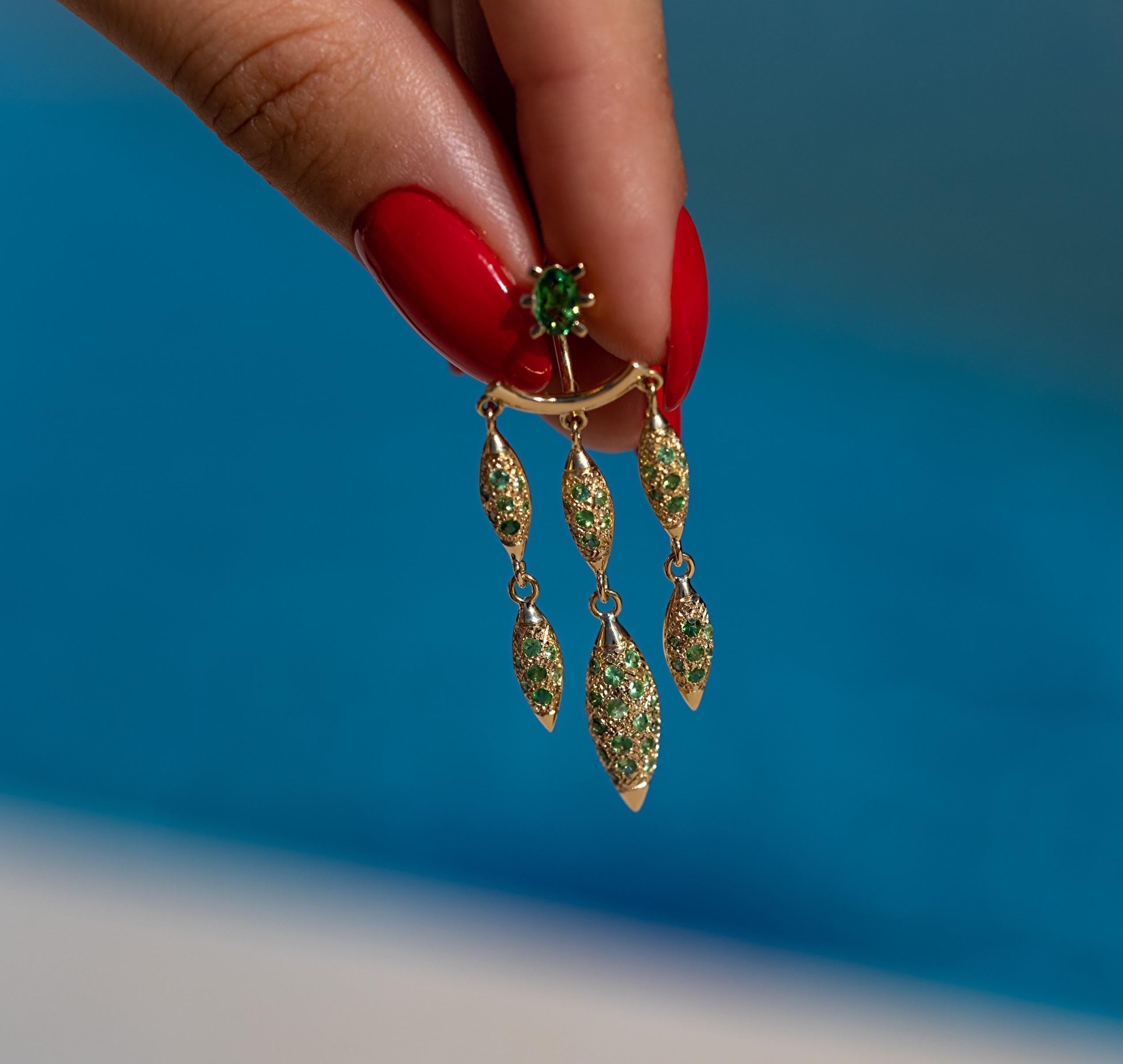 The ‘Grain’, chandelier ear jackets are crafted in 18K yellow gold, hallmarked in Cyprus. These impressive chandelier earrings come in a highly polished finish, set with Green Tsavorite Garnets, totalling 1,87 Cts. The pair of oval cut 0,84 Cts,