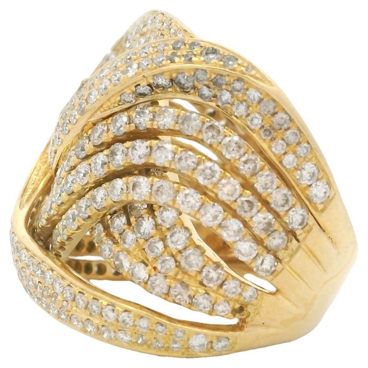 Realizzato in Italia in lussuoso oro giallo 18 carati, questo sorprendente anello cocktail incrociato presenta uno scultoreo design a onda con pavé di diamanti rotondi taglio brillante incastonati a circa 5,00 carati. Le eleganti file intrecciate