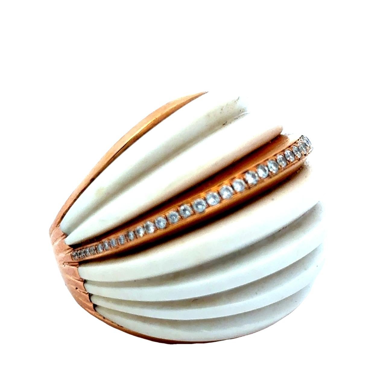Make a bold and elegant statement with this sculptural 18K rose gold ring, showcasing a dramatic fluted dome carved from natural white coral. Designed with exceptional craftsmanship, the ring features a sleek center band channel-set with