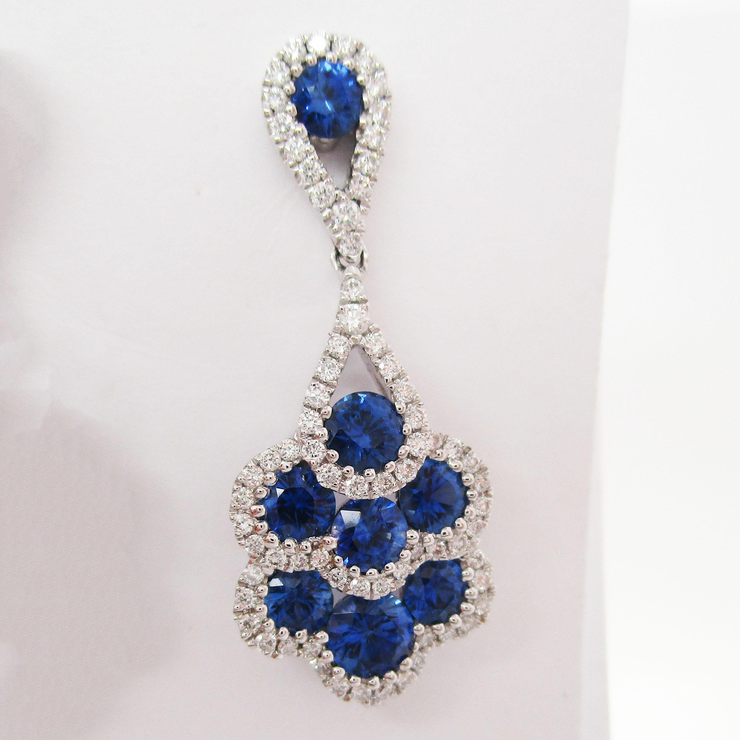 This is an absolutely breathtaking pair of earrings in 18k white gold with a stunning selection of bright white diamonds and rich royal blue sapphires. The earrings have a classic dangle layout that is fully articulated for an excellent range of