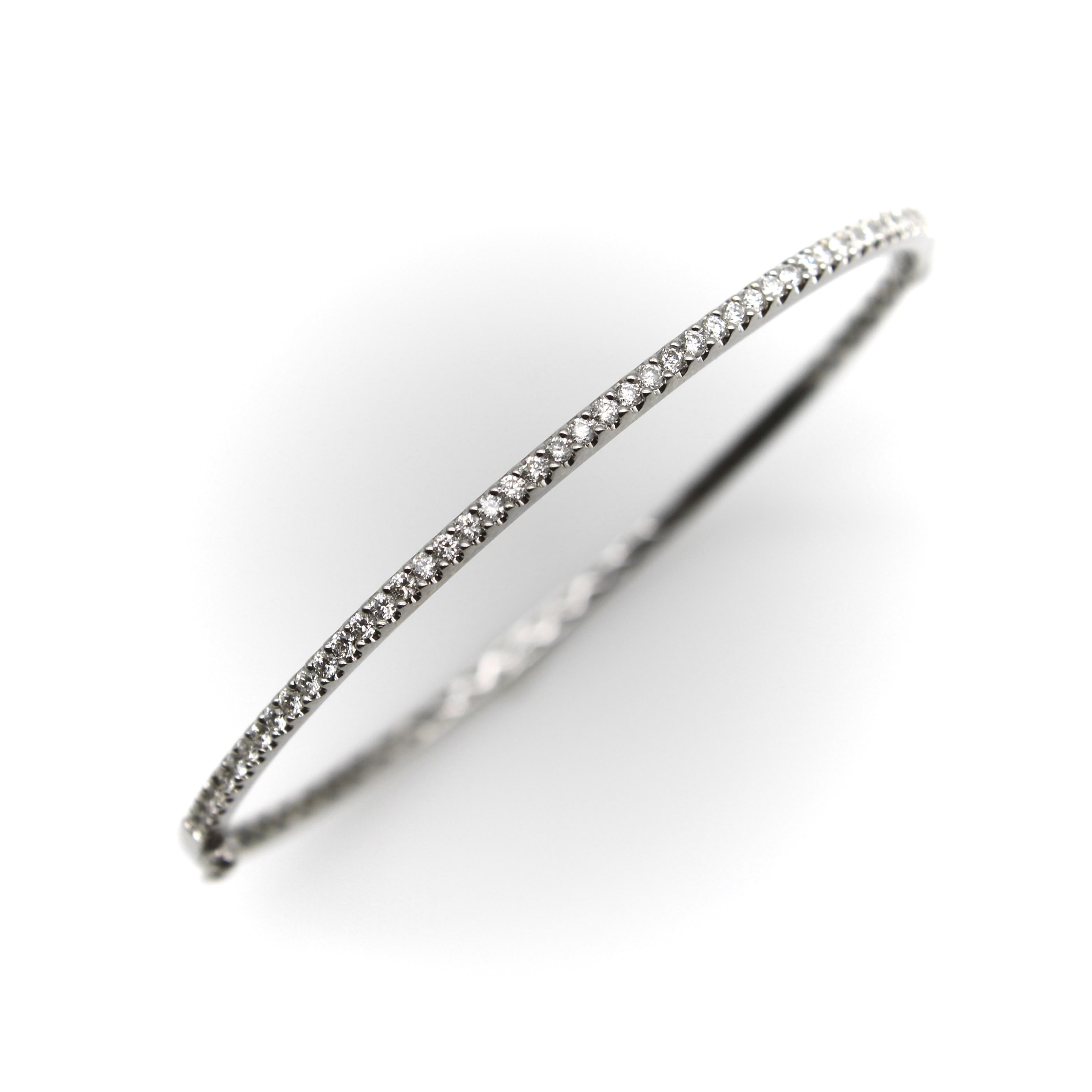 Ce bracelet en or blanc 18k est incrusté d'une ligne de 49 diamants étincelants. Les diamants sont sertis dans une monture partagée. Dans le souci du détail, l'intérieur du bracelet est orné d'un magnifique treillis sur tout le pourtour. Le bracelet
