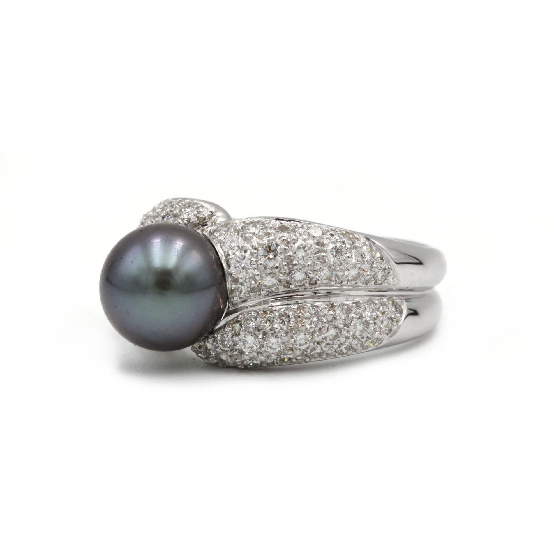Cette bague moderne met en valeur une perle de Tahiti de 10,5 mm lustrée, nichée entre des rubans de diamants taille brillant légèrement incurvés. Réalisé en or blanc 18 carats, ce bijou au design épuré rappelle à la fois la fluidité et la