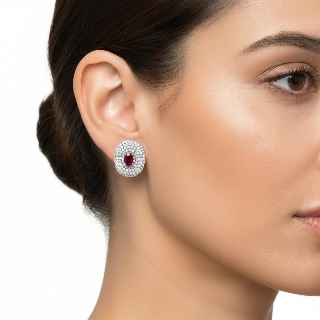 Cette élégante paire de boucles d'oreilles contemporaines est fabriquée de manière experte en or blanc 18 carats, avec des fonds en or blanc 14 carats pour une durabilité et un confort accrus. Chaque boucle d'oreille est ornée d'un rubis rouge