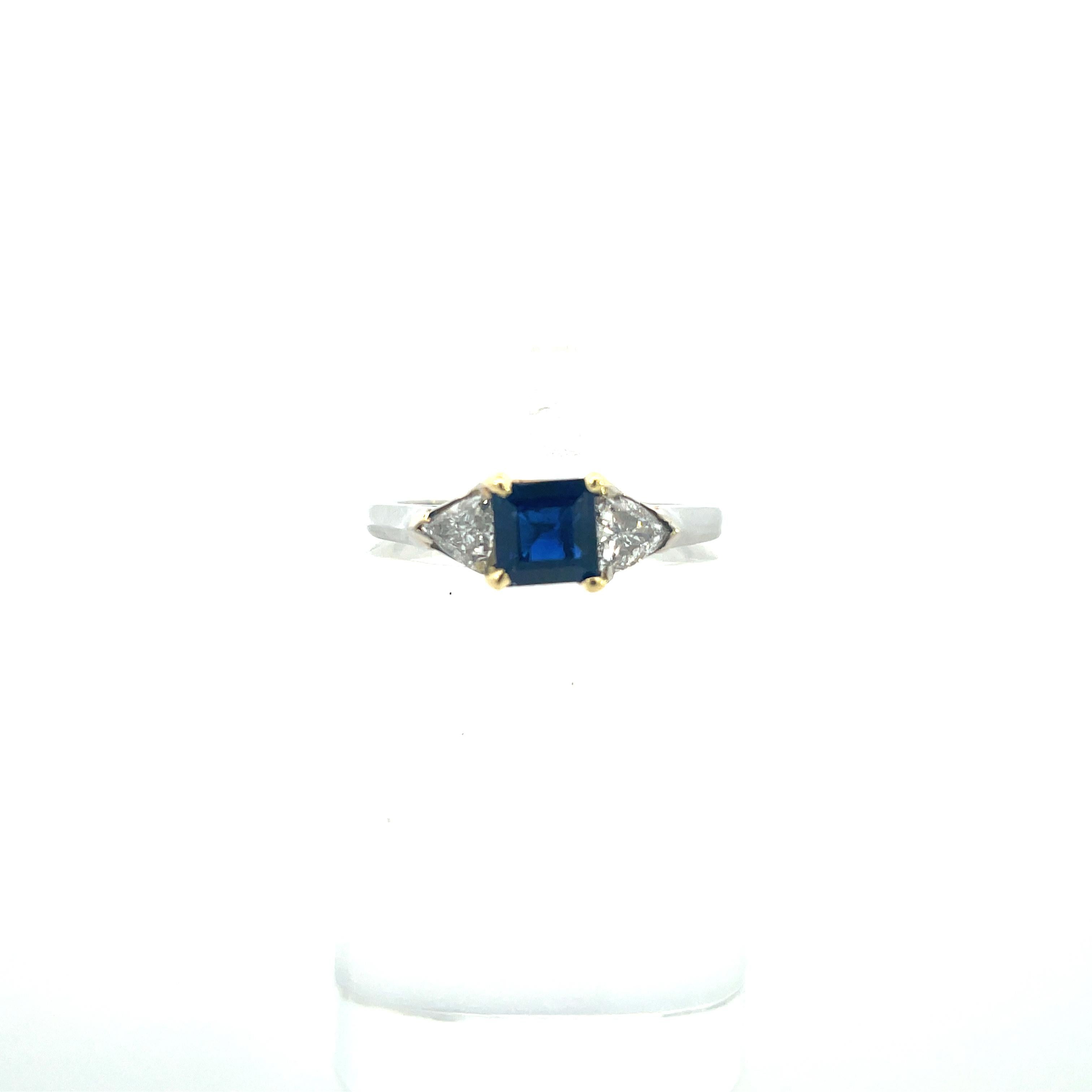 This gorgeous piece is a contemporary, platinum and 18k yellow gold ring with blue sapphire and trillion-cut diamonds. This ring features a unique combination of components, with the blue sapphire being square-cut and the diamonds being