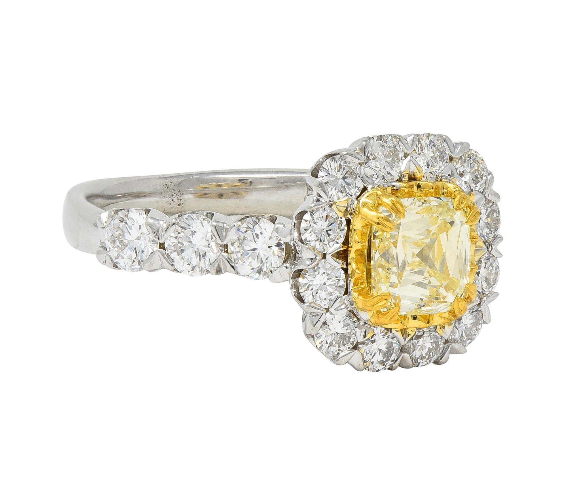 Centering a cushion-shaped modified brilliant cut diamond weighing 1.01 carats total
S to T range color with SI2 clarity - set with split talon prongs in scalloped yellow gold mount
With a halo surround and shoulders prong set with round brilliant