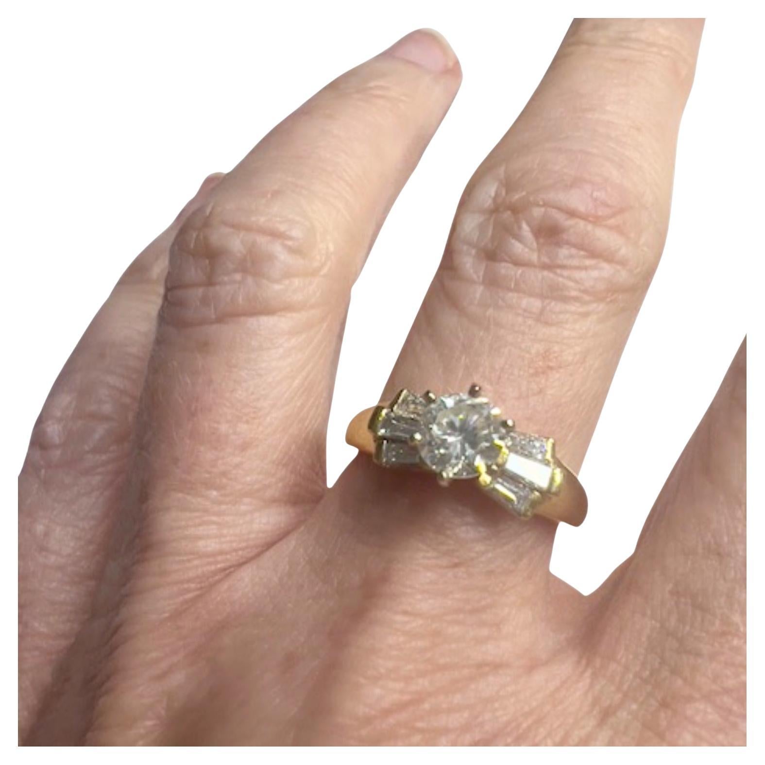Questo anello contemporaneo del XX secolo è realizzato in oro 18 carati e presenta un totale di sette diamanti. Pesa 3,90 grammi e misura ES 15 / EU 55 / US 7.25. L'anello include un diamante centrale di 0,60 carati, con purezza SI e colore W (H) -