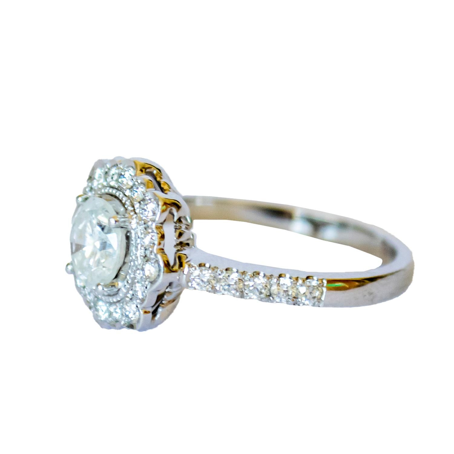 Cette bague contemporaine du XXe siècle est réalisée en or 18 carats et ornée de diamants. Il pèse 5,18 grammes et a une taille de 17/57. Le diamant central est taillé en brillant, pèse 0,90 carats et est de pureté PI2 et de couleur G-H. D'autres