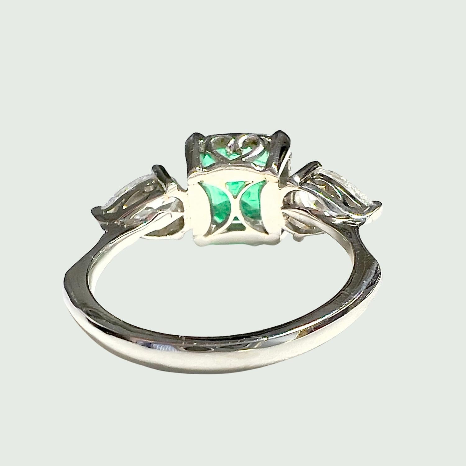 This contemporary ring from the 20th Century is crafted in platinum and features a Colombian emerald and tear-shaped Diamonds. The central emerald is cut in an emerald shape and weighs 3.82 carats. The Diamonds total 1.65 carats and are of VS