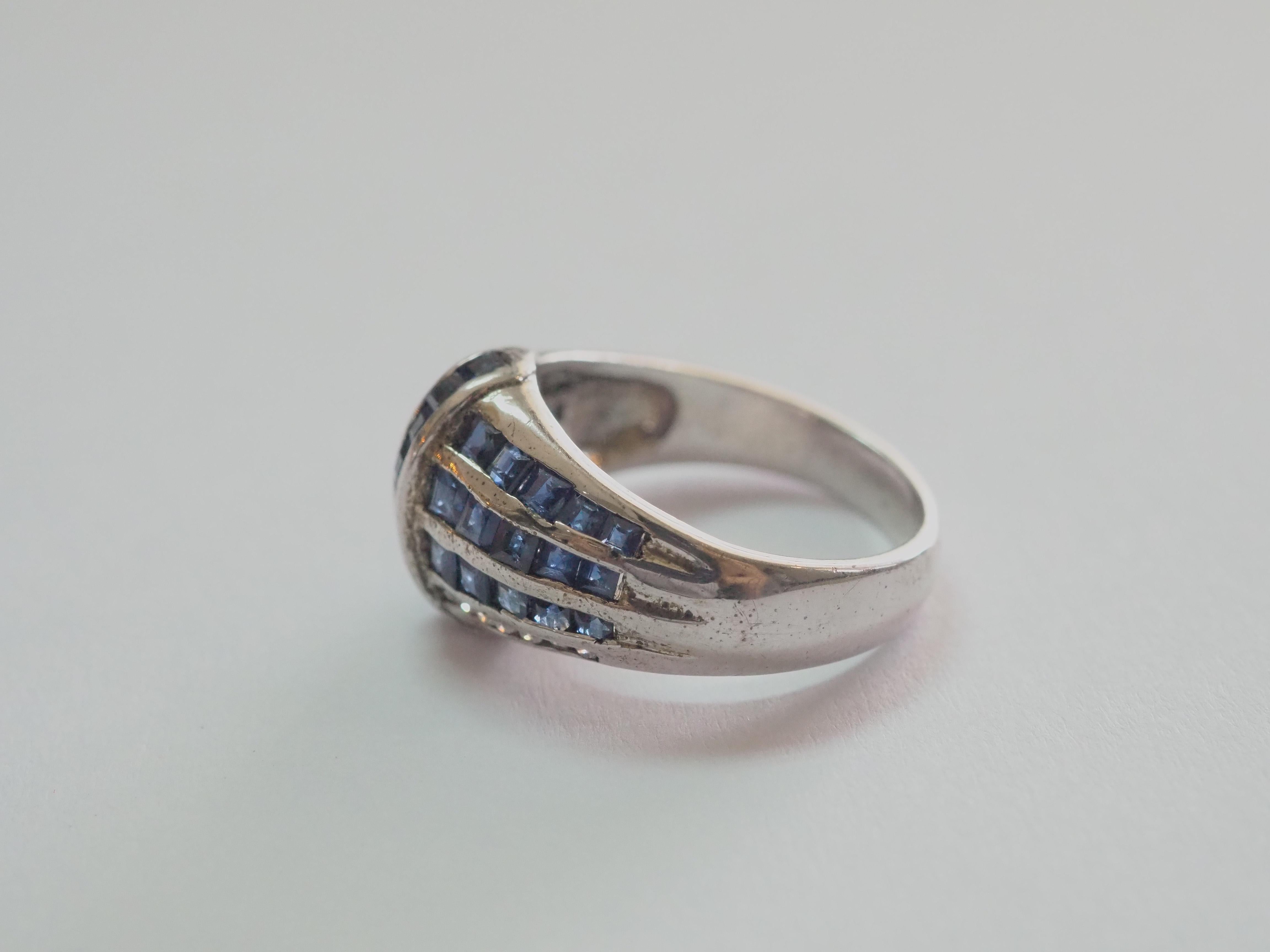 Opportunity starting at only 50!
This ring is a beautiful swirl ring in solid sterling silver. The ring is decorated by natural squared blue sapphires channeled into many lines overlapping one another. The white stone are Cubic Zirconia. The blue