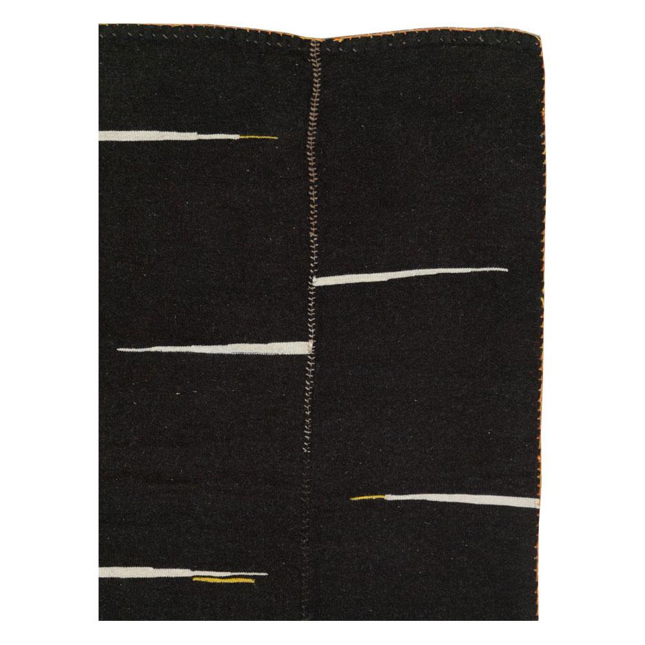 Un tapis d'accentuation moderne perse Kilim à tissage plat, fabriqué à la main au cours du 21e siècle avec un design contemporain en noir.

Mesures : 6' 2