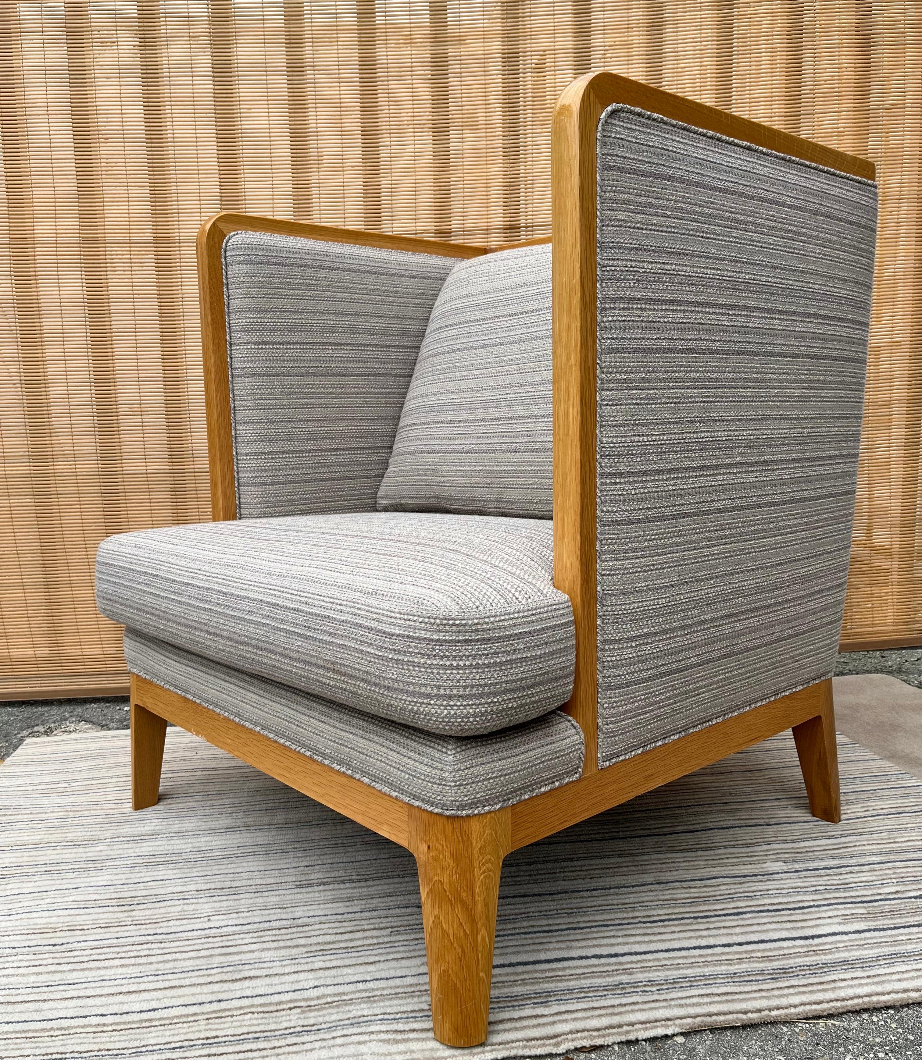 Contemporary 21st century upholstered wingback lounge chair. Circa 2010s. 
Features a simple silhouette and a sleek modern take on the traditional Wingback chair designs. An excellent hight end craftsmanship with a solid wood frame with rounded