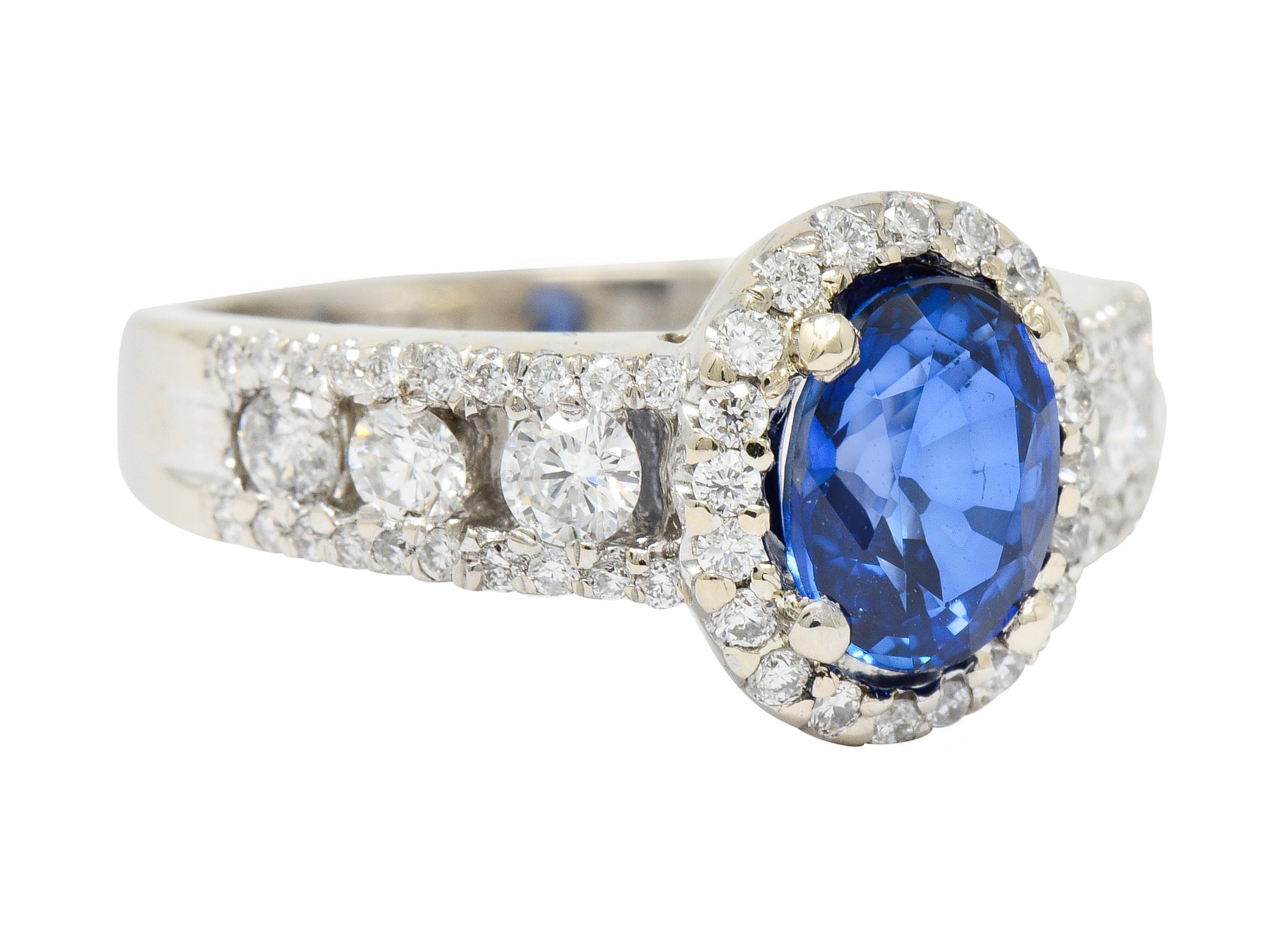 Centering an oval cut sapphire weighing approximately 1.36 carats, transparent and deeply royal blue in color

With a halo of round brilliant cut diamonds weighing approximately 0.30 carat, G to I color with SI clarity

Flanked by split shoulders