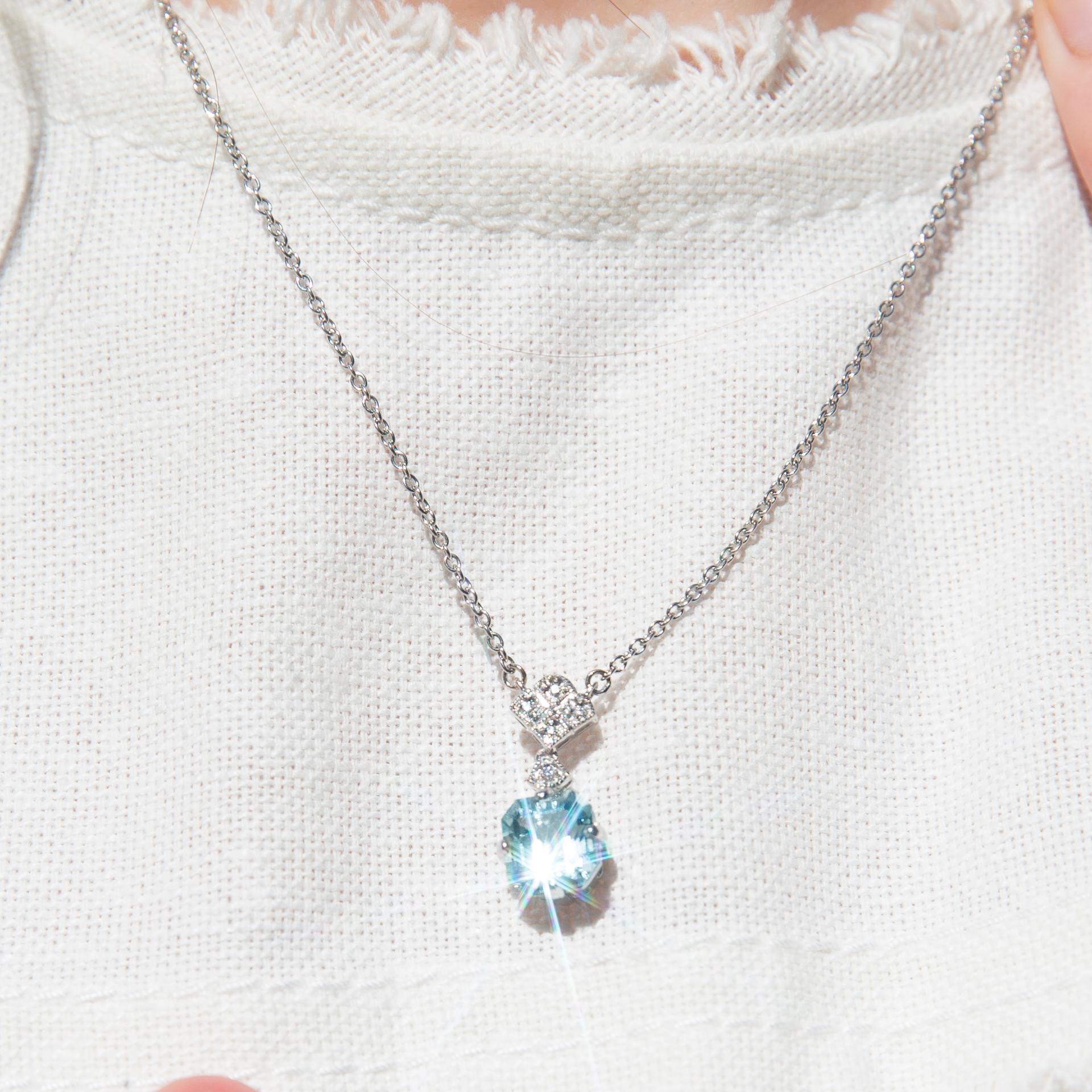 Crafted in platinum, this fabulous contemporary adornment features a stunning emerald cut aquamarine in a claw setting and articulating from a a diamond-shaped bail set with shimmering diamonds and threaded with a fine chain. The Kailani Pendant &