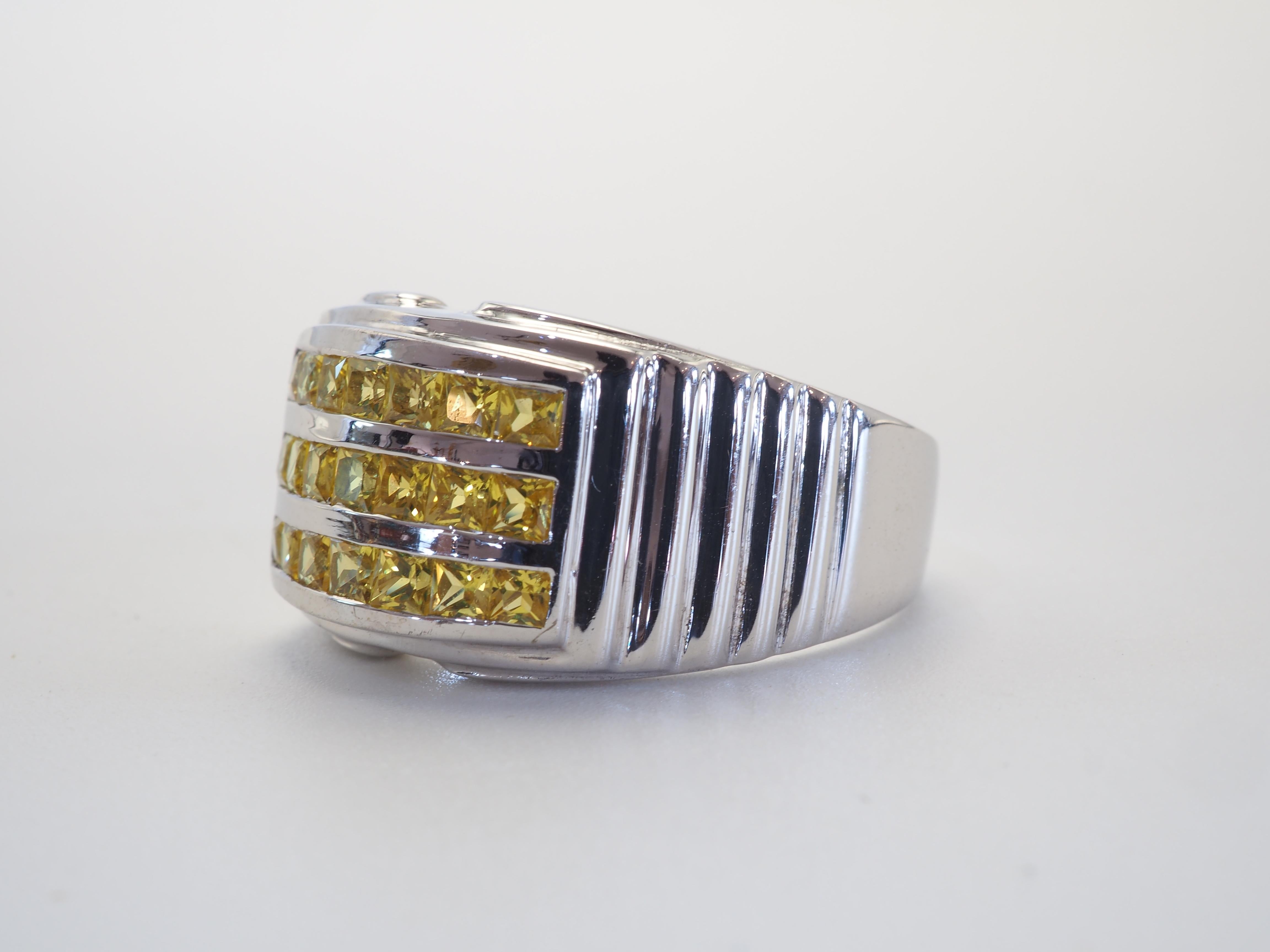 This ring is a beautiful wide band ring in solid sterling silver. The ring is decorated by natural squared yellow sapphires masterfully channeled into 3 rows. The vibrant yellow gemstone is one of the most popular in the gem world with rich history