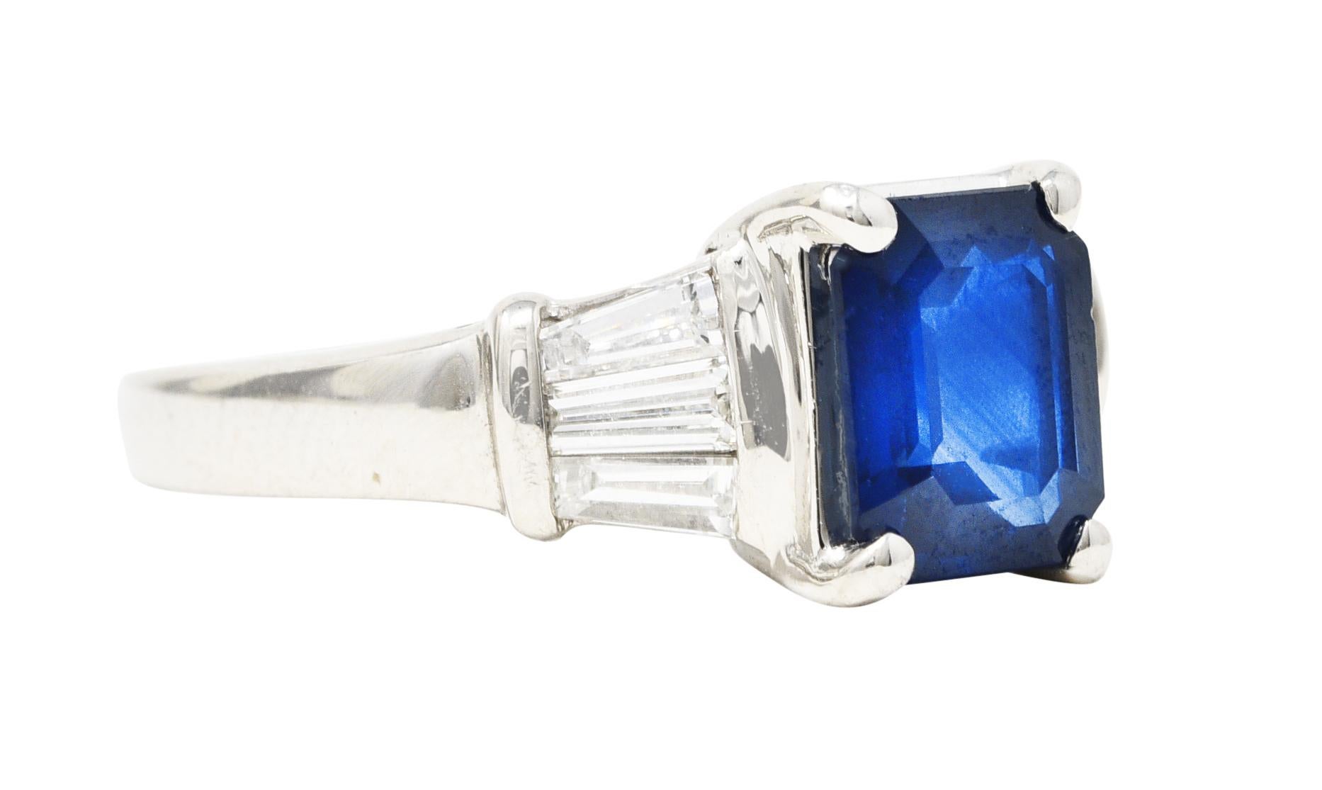Mit einem korbgefassten Saphir im Smaragdschliff von 1,70 Karat. Augensauber mit tief königsblauer Farbe. Flankiert von runden Schultern, die bündig mit spitz zulaufenden Diamanten im Baguetteschliff besetzt sind. Mit einem Gewicht von insgesamt