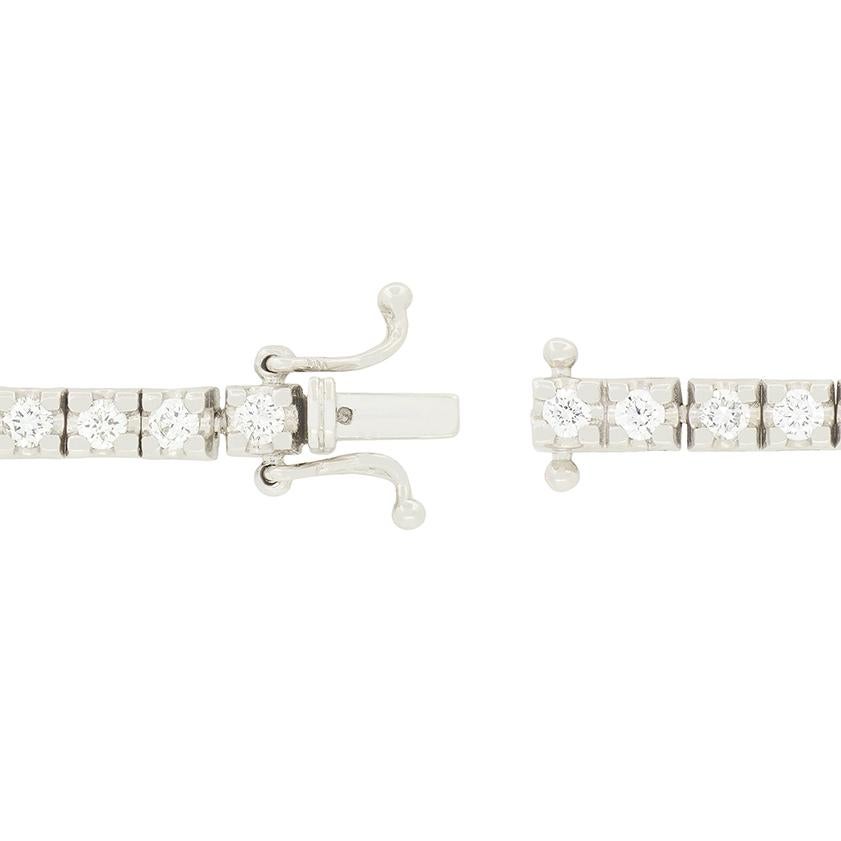 Cincuenta y tres brillantes diamantes envuelven la muñeca de quien los lleva en esta impresionante pulsera tenis. Los diamantes redondos de talla brillante pesan un total de 2,65 quilates, con un color a juego de G y una claridad de VS1 a VS2. Cada