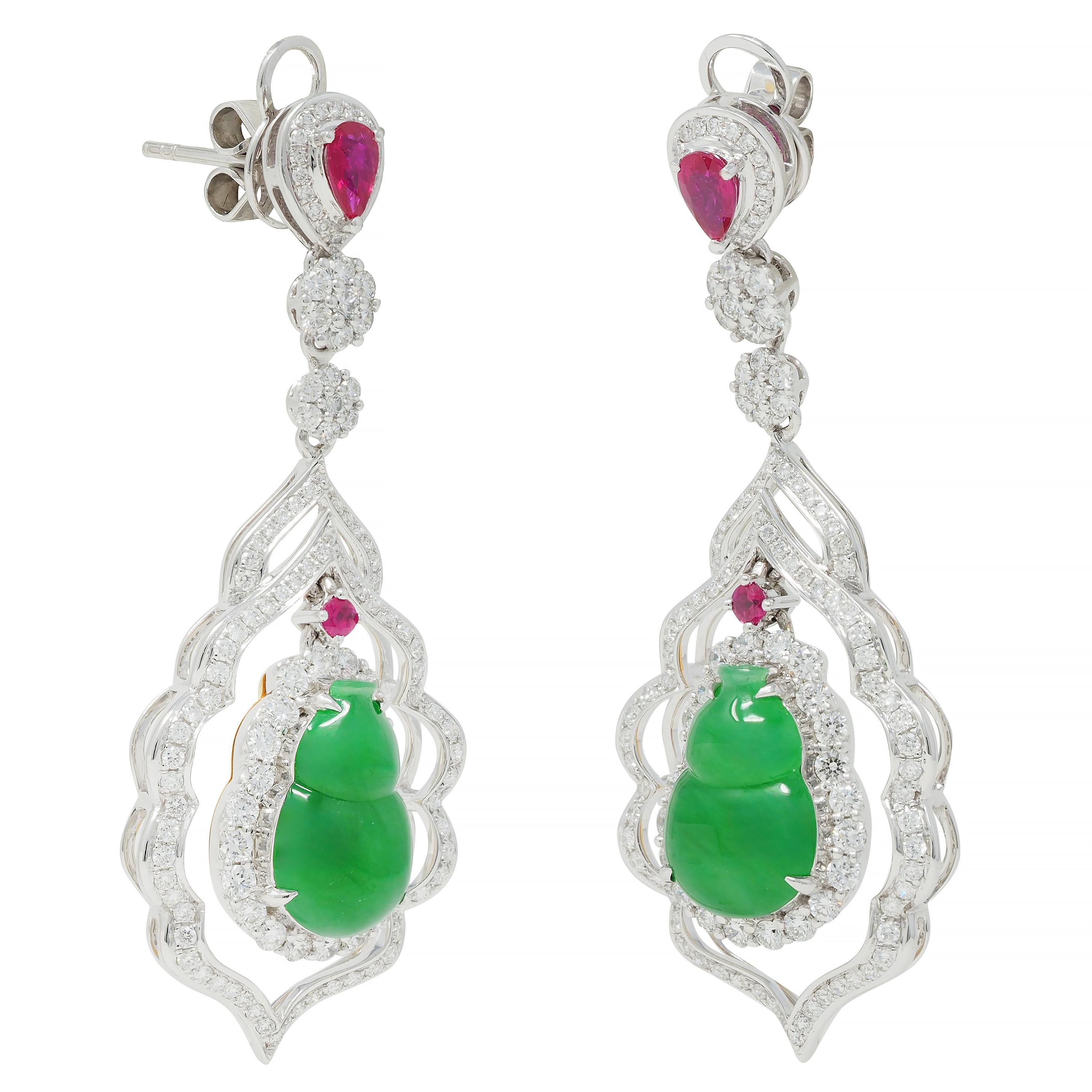 Designed as pear-shaped surmounts suspending floral clusters and undulating biomorphic navette form drops 
Featuring carved jade plaques depicting gourds - measuring 8.5 x 13.0 mm 
Translucent medium vibrant green in color - backed by yellow gold