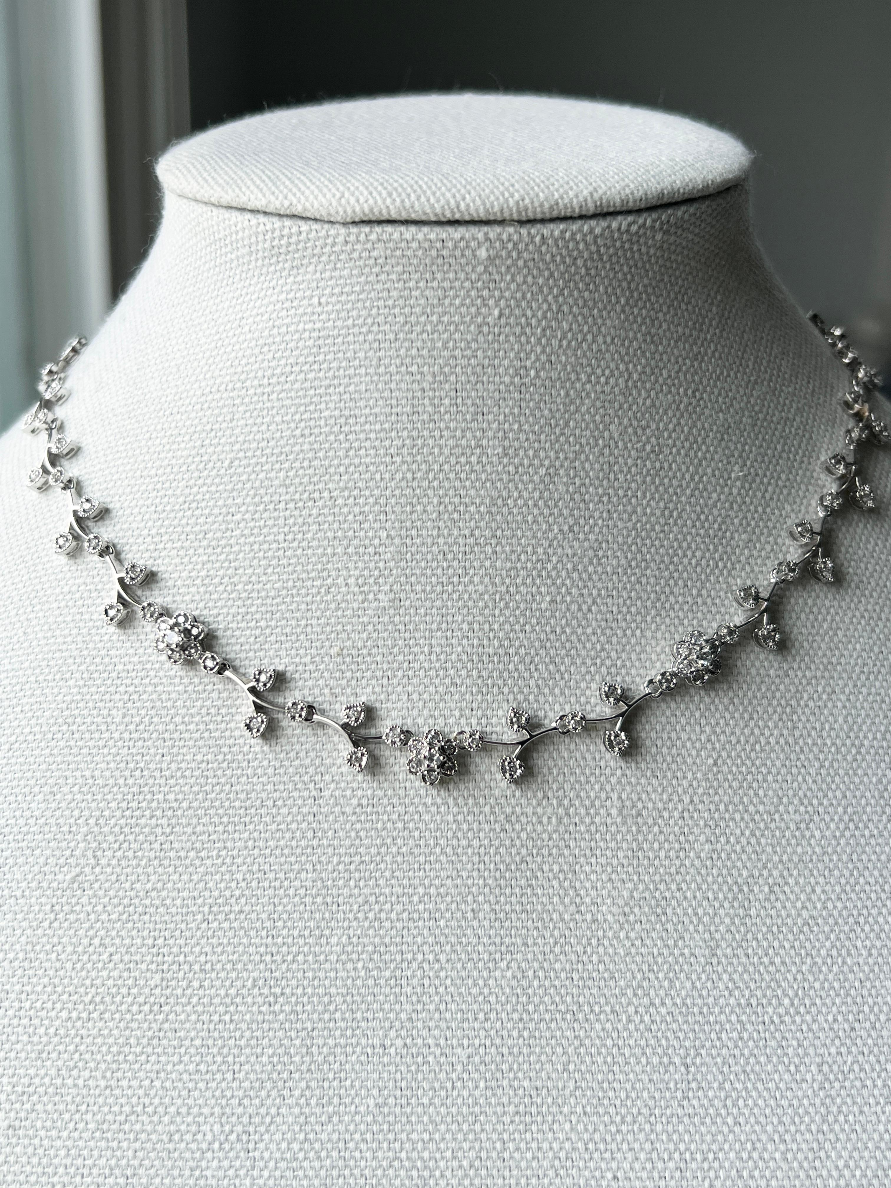 Una collana floreale contemporanea in oro bianco 14 carati e diamanti. Disegnato con un delicato motivo a vite di 16 pollici, con incastonati centouno diamanti tondi brillanti per un peso totale di circa 2,79 carati, con colore I-J e purezza I1-I2.