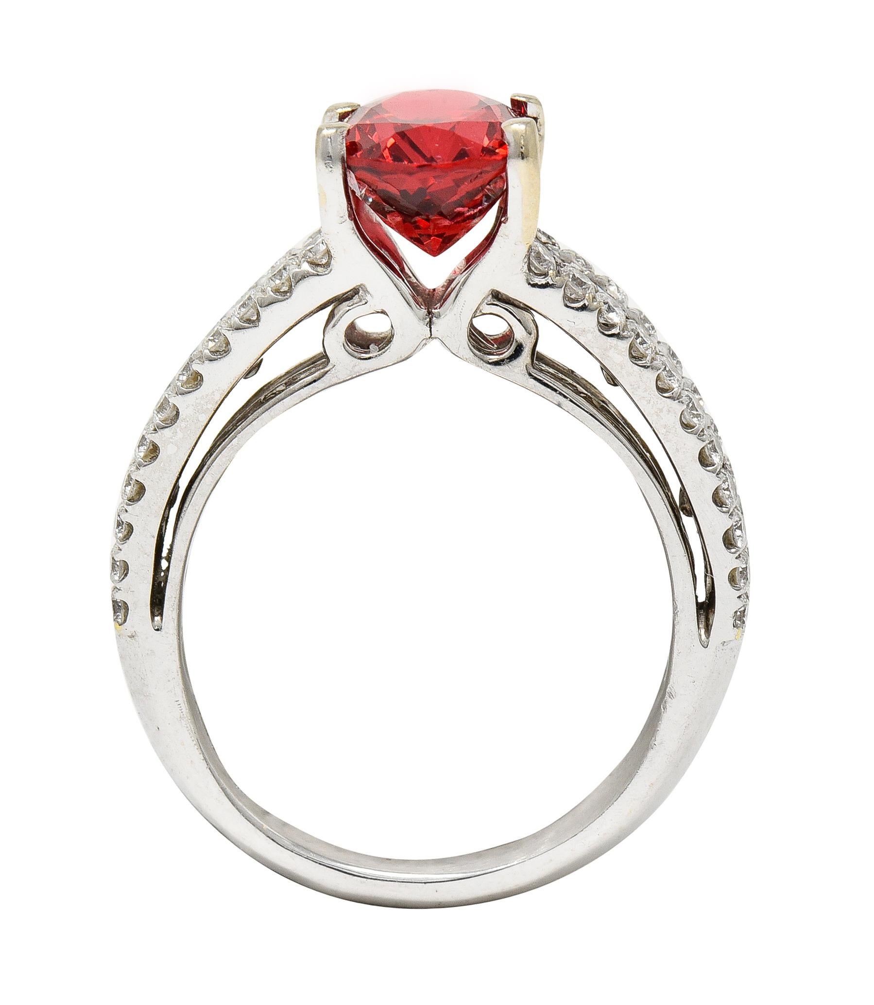 Centering an oval cut spinel weighing approximately 2.03 carats total 
Transparent bright medium orangish-red in color - prong set
Flanked by three rows of round brilliant cut diamonds
Weighing approximately 0.82 carats total
G/H color with VS2