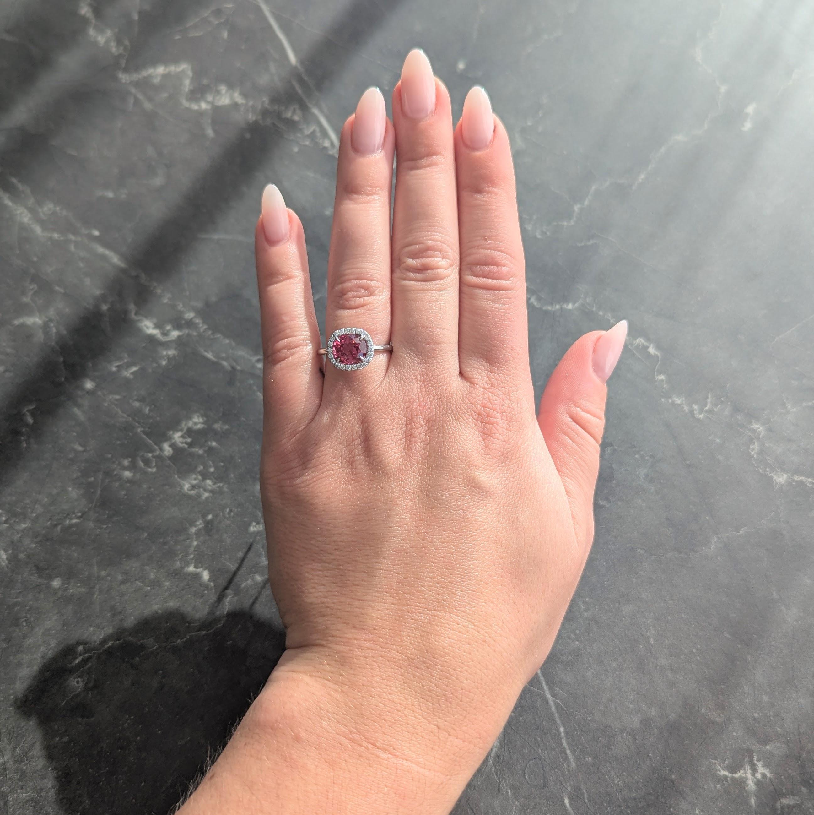 Con uno spinello misto taglio cuscino di circa 2,60 carati
Trasparente con colore rosa violaceo saturo - incastonato in un cestino
Circondato da un'aureola di diamanti rotondi taglio brillante
Con un peso totale di circa 0,25 carati
Occhi puliti e