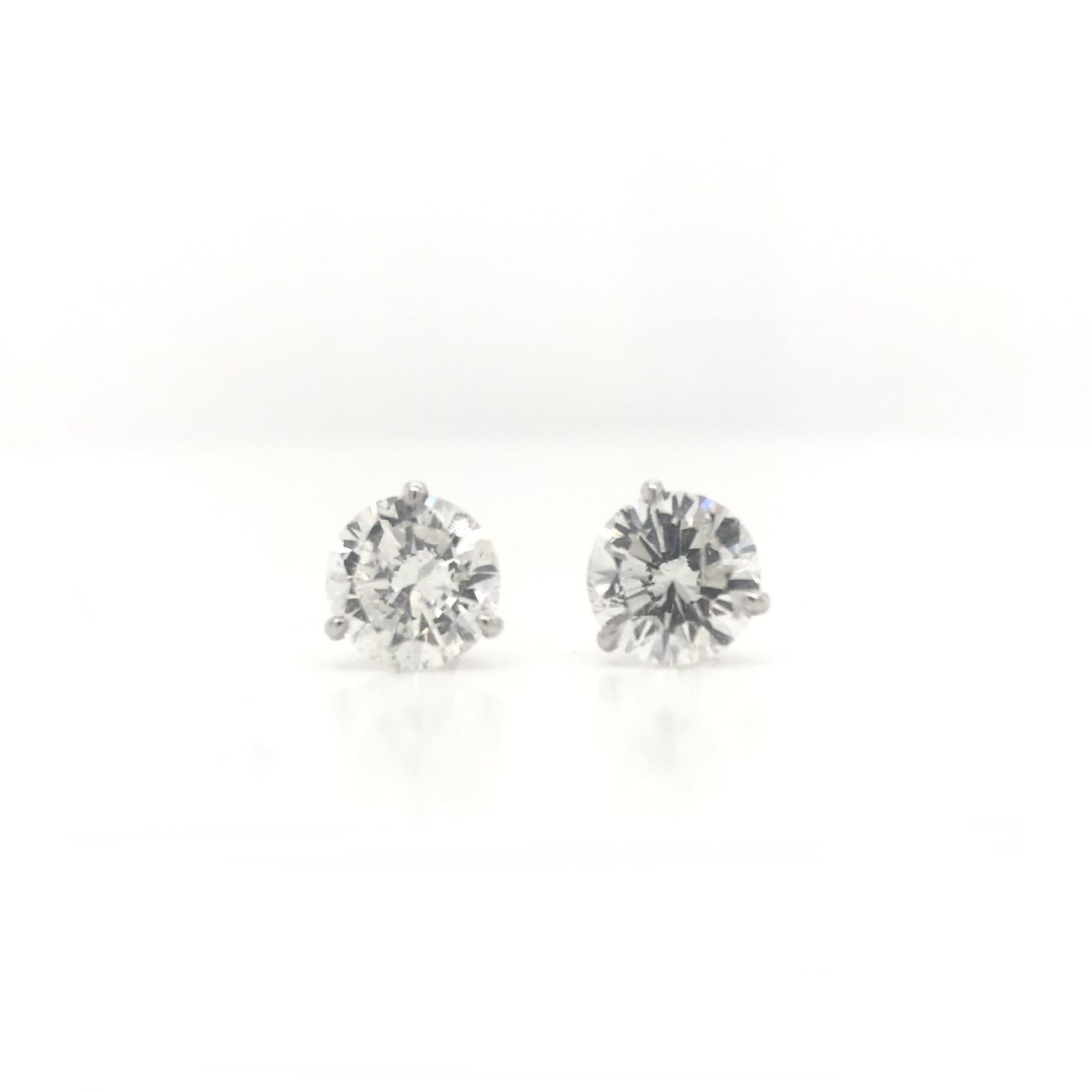 These contemporary diamond stud earrings feature 14K white gold “Martini” style settings. Each setting has three prongs arranged in a very simple design; playfully resembling a martini glass. The diamonds have a total combined diamond weight of