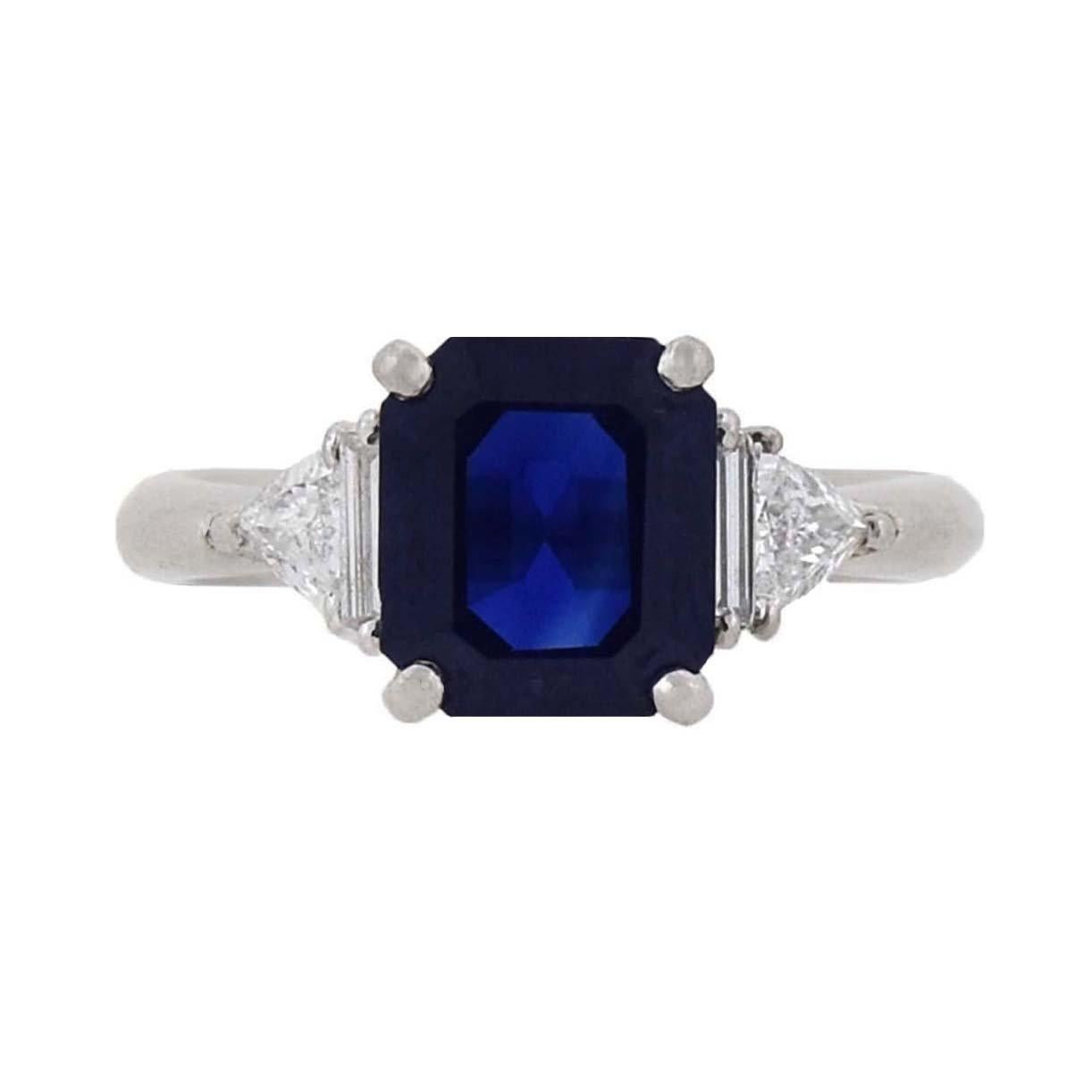 A gorgeous Estate sapphire and diamond ring! Crafted in platinum, this beautiful piece adorns a luscious 3.01ct dark blue sapphire at the center of a stunning setting. The vivid stone rests in a raised prong setting and is flanked on either side by