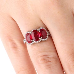 Anillo contemporáneo de tres piedras con un rubí birmano ovalado certificado de 3,04 ct y halo de diamantes