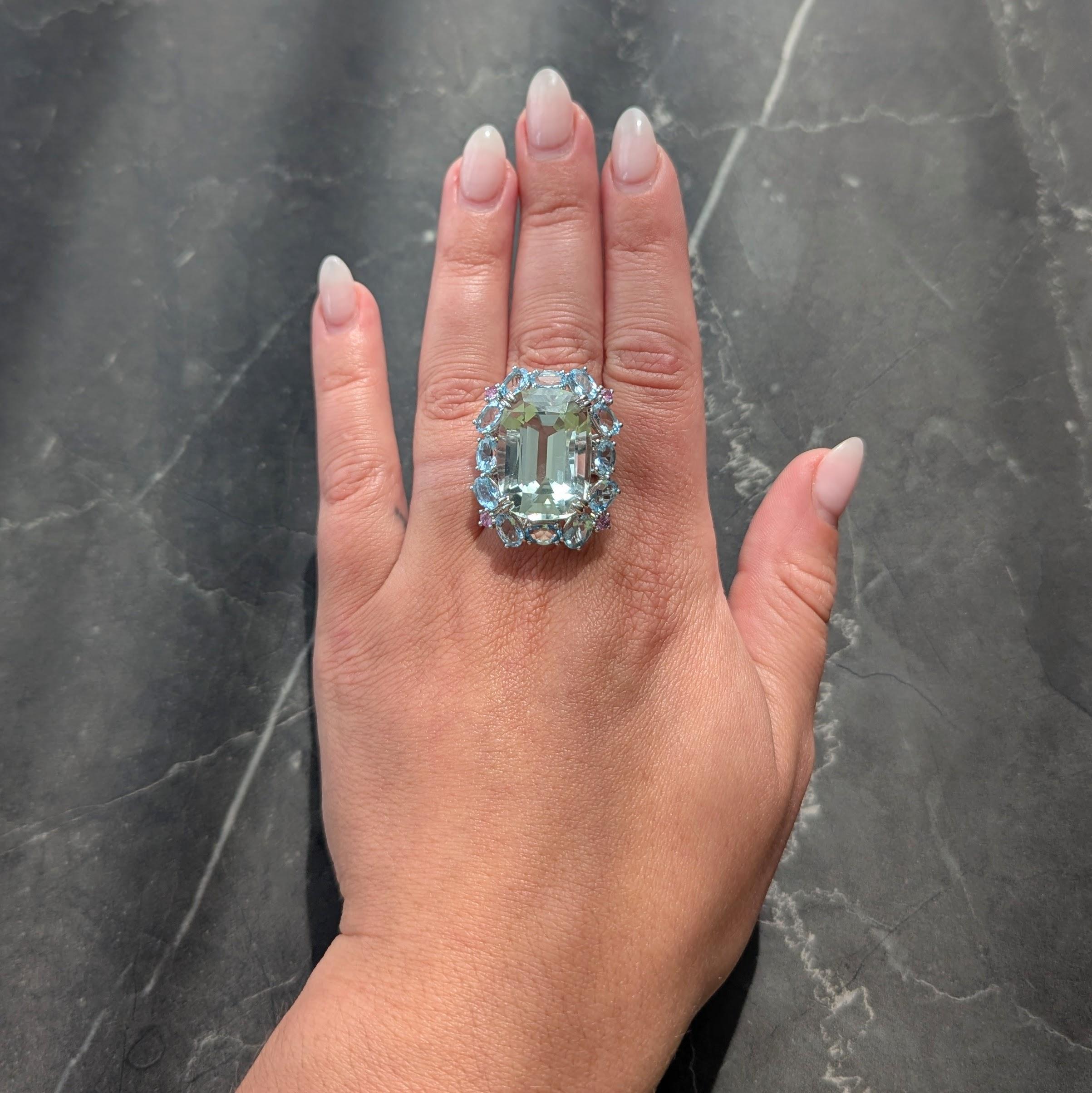 Centering a cushion cut prasiolite weighing 26.75 carats - transparent very light pastel green in color
Set with split talon prongs with a halo surround of prong set oval cut aquamarines
Weighing 4.79 carats total - transparent light blue in
