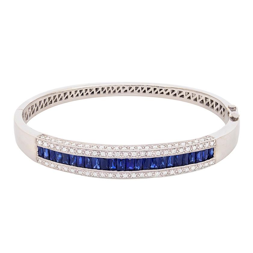 This beautiful bracelet consists of 24 perfectly calibrated French cut sapphires. The stones are a stunning royal blue and have a combined weight of 3.20 carat. Along the sapphires are two rows of grain set diamonds. The round brilliant diamonds