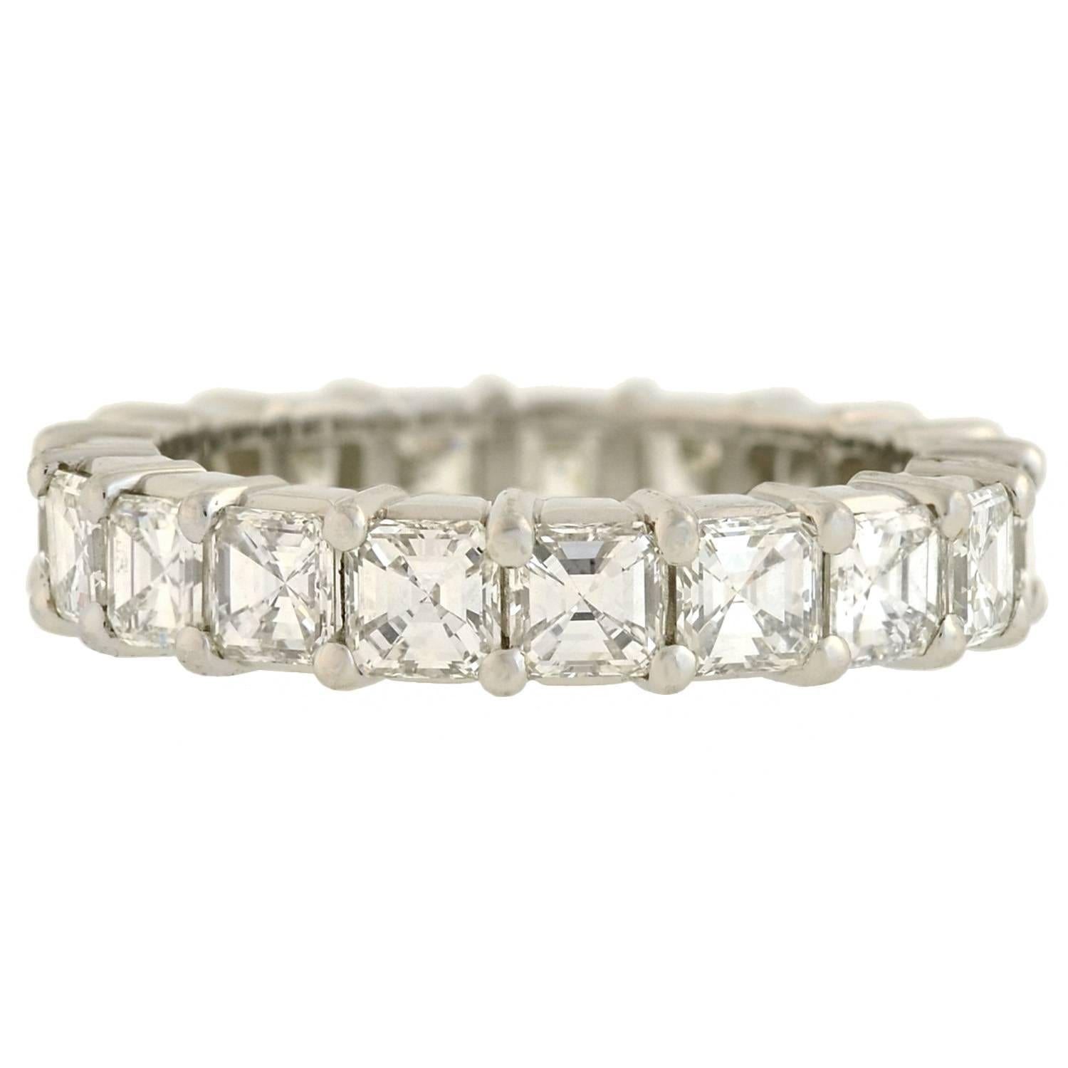 This Estate diamond eternity band is quite spectacular! Crafted in platinum, the ring features a row of 19 outstanding Asscher Cut diamonds, which carry seamlessly around the surface in a shared prong setting. The sparkling stones have H-I range